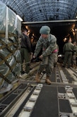 Staff Sgt. Whitney Armstrong chains down cargo on a McChord AFB, Wash., C-17 in Toledo, Ohio, Jan. 30. The C-17 from McChord AFB took off from Charleston AFB to pick up cargo in Ohio before departing to Port-au-Prince, Haiti. Pallets and cargo must be precisely aligned along floor rollers in order to perform a smooth transfer of cargo onto the aircraft. Sergeant Armstrong is a loadmaster with the 179th Logistics Readiness Squadron. (U.S. Air Force Photo/Airman 1st Class Lauren Main)