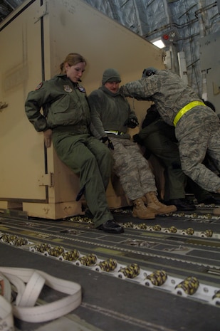 Airmen from the 179th Logistics Readiness Squadron and the 8th Airlift Squadron load crates of supplies onto a McChord AFB, Wash., C-17 in Toledo, Ohio, Jan. 30. The C-17 departed from Charleston AFB and made a brief three-hour stop to pick up supplies in Ohio to transport to Port-au-Prince, Haiti. The aircraft was loaded with several bins of equipment, pallets and two mobile lighting stations. (U.S. Air Force Photo/ Airman 1st Class Lauren Main)