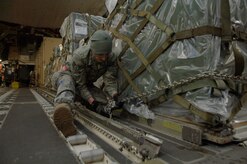 Staff Sgt. Whitney Armstrong chains down cargo on a C-17 in Toledo, Ohio, Jan. 30. The C-17 from McChord AFB, Wash., took off from Charleston AFB to pick up cargo in Ohio before departing to Port-au-Prince, Haiti. Upon delivering the supplies, the aircraft returned to the United States and made a stop in Orlando, Fla.,to drop off six American evacuees before returning to Charleston AFB. Sergeant Armstrong is a loadmaster with the 179th Logistics Readiness Squadron. (U.S. Air Force Photo/Airman 1st Class Lauren Main)