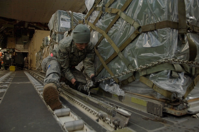 Staff Sgt. Whitney Armstrong chains down cargo on a C-17 in Toledo, Ohio, Jan. 30. The C-17 from McChord AFB, Wash., took off from Charleston AFB to pick up cargo in Ohio before departing to Port-au-Prince, Haiti. Upon delivering the supplies, the aircraft returned to the United States and made a stop in Orlando, Fla.,to drop off six American evacuees before returning to Charleston AFB. Sergeant Armstrong is a loadmaster with the 179th Logistics Readiness Squadron. (U.S. Air Force Photo/Airman 1st Class Lauren Main)