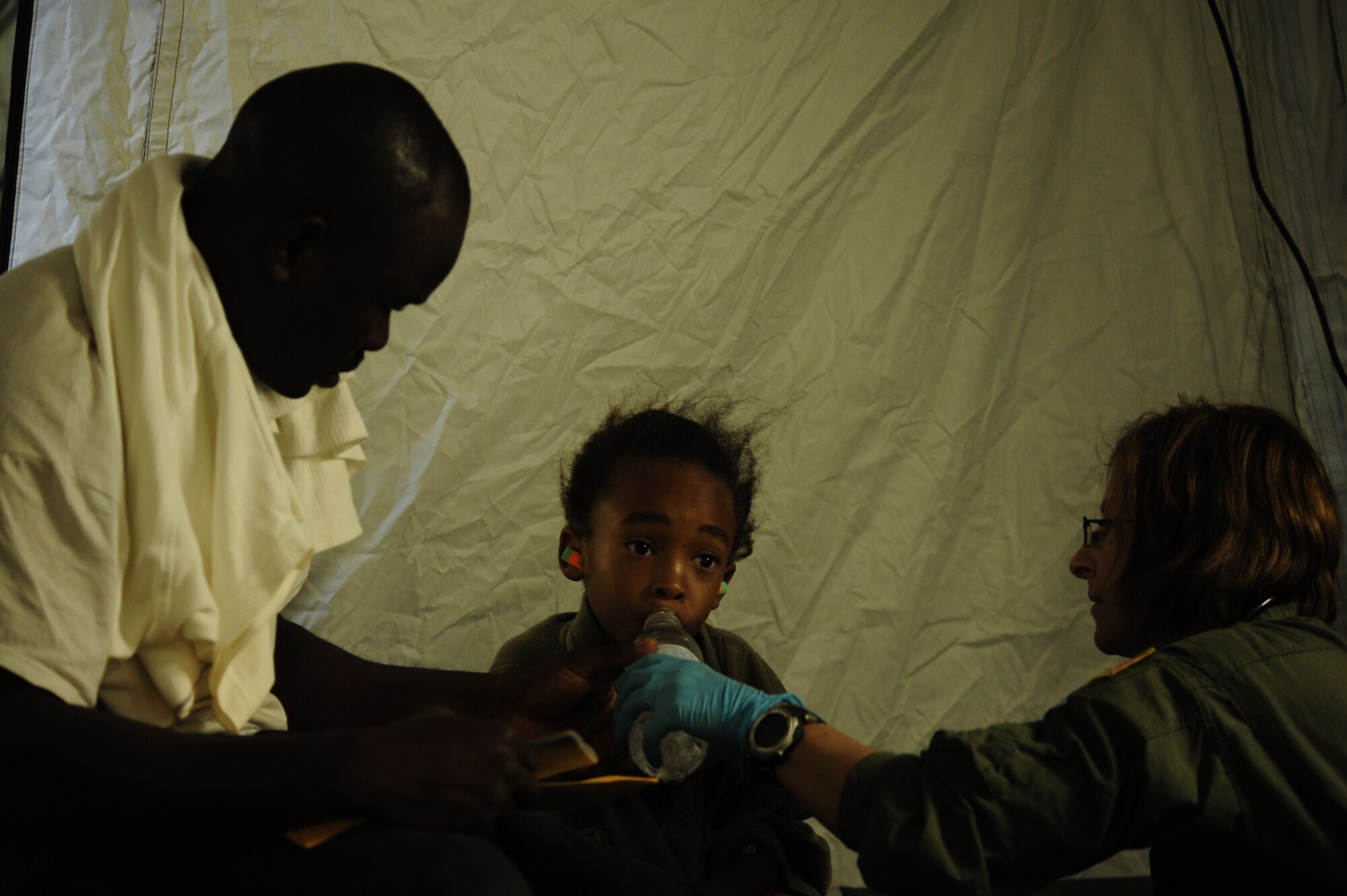 A six-year-old Haitian boy is given water by a medical technician with 1st Special Operations Support Squadron at the Toussaint Louverture International Airport in Port-au-Prince, Haiti, Jan. 19, 2010. The boy will be airlifted to a hospital in southern Florida. (U.S. Air Force photo by Tech. Sgt. James L. Harper Jr./Released)