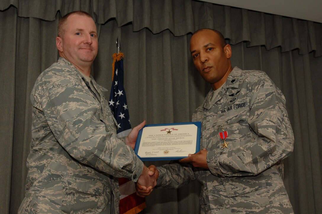 Col. Dale Agner, 1st Special Operations Medical Group commander, presents the citation accompanying the Bronze Star to Lt. Col. Terence Mitchell, 1st SOMDG chief of medical staff, at the 8th Special Operations Squadron auditorium at Hurlburt Field Feb. 1. Colonel Mitchell served as a staff physician for a joint task force in support of Operation Iraqi Freedom from Aug. 20, 2008 to Jan. 7, 2009. (U.S. Air Force photo by Senior Airman Matthew Loken) 