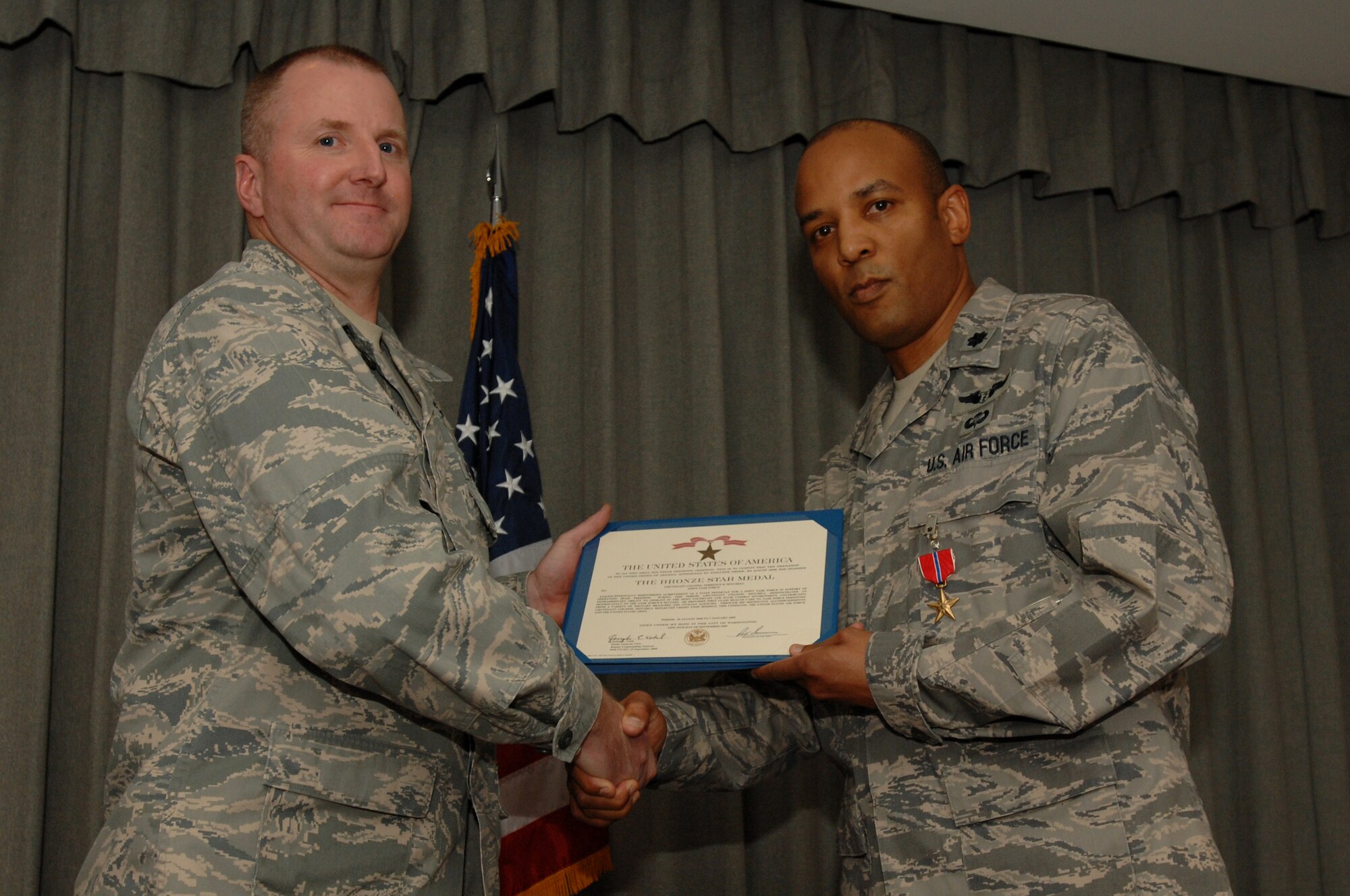 Col. Dale Agner, 1st Special Operations Medical Group commander, presents the citation accompanying the Bronze Star to Lt. Col. Terence Mitchell, 1st SOMDG chief of medical staff, at the 8th Special Operations Squadron auditorium at Hurlburt Field Feb. 1. Colonel Mitchell served as a staff physician for a joint task force in support of Operation Iraqi Freedom from Aug. 20, 2008 to Jan. 7, 2009. (U.S. Air Force photo by Senior Airman Matthew Loken) 