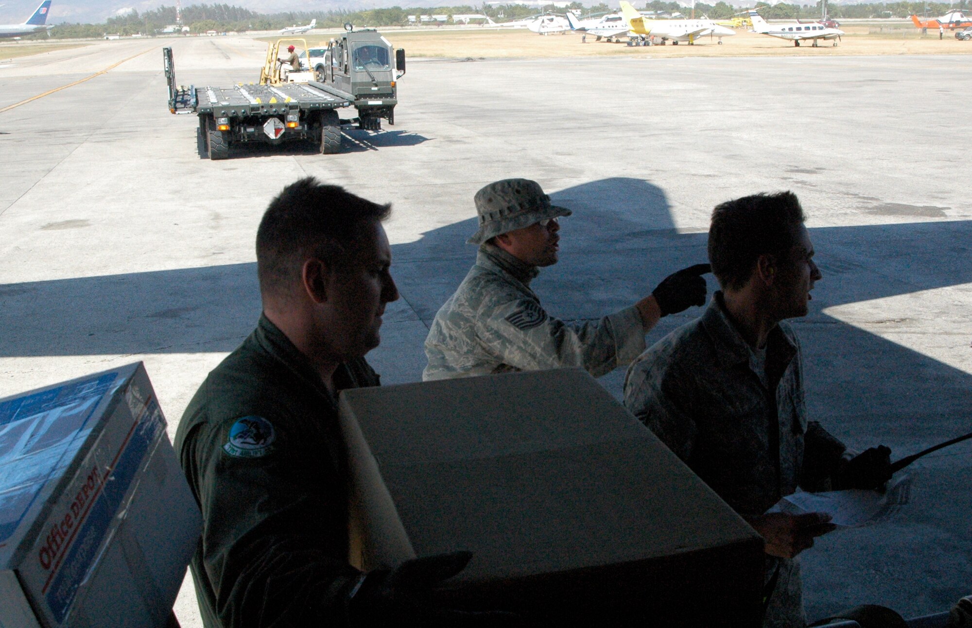 Tech. Sgt Barry Burkitt hands package after package to awaiting aerial transporters Jan. 30 at Port-au-Prince, Haiti. The packages were loaded onto a C-130 Hercules at Homestead Air Reserve Base, Fla., and transported to the earthquake-devastated island nation as part of ongoing relief efforts. The C-130 is operated by the 302nd Airlift Wing, one of two wings assigned to the 35th Expeditionary Airlift Squadron, which supports Air Expeditionary Force Coronet Oak. The members are deployed in support of Haiti earthquake relief operations, some of which are based at Muniz Air Base, Puerto Rico. (U.S. Air Force photo/Staff Sgt. Stephen J. Collier)