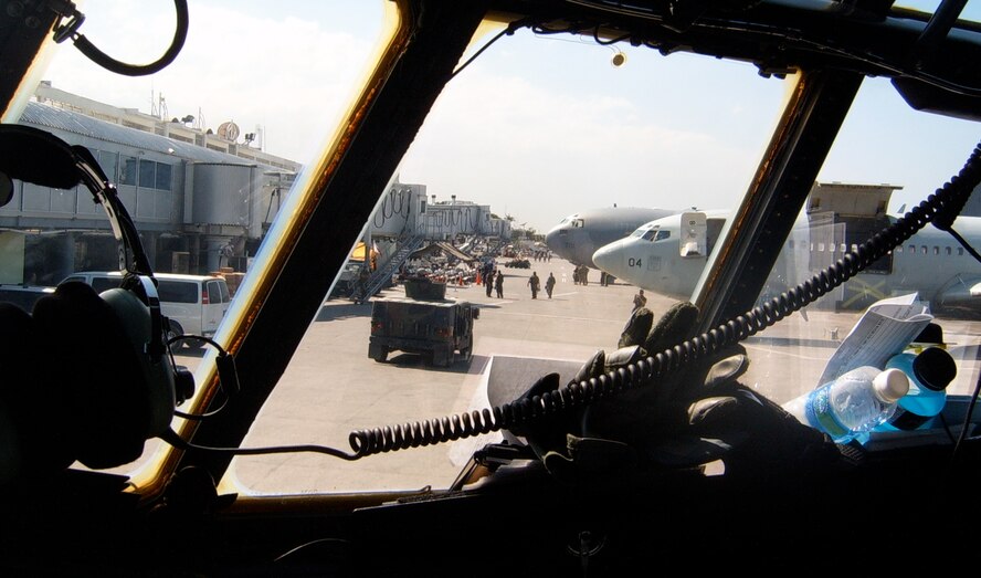Aircraft from the U.S. and other world countries, as seen from the cockpit of an Air Force Reserve C-130 Hercules, crowd the airport ramp Jan. 30 at Port-au-Prince's airport in Haiti. Aircraft in the dozens continue to descend on the Haitian capital everyday, delivering needed supplies to awaiting needy. Airmen from the 302nd Airlift Wing, for which is the C-130 is assigned, are currently assigned to the 35th Expeditionary Airlift Squadron, which supports Air Expeditionary Force Coronet Oak. The members are deployed in support of Haiti earthquake relief operations. (U.S. Air Force photo/Staff Sgt. Daniel Osorio)