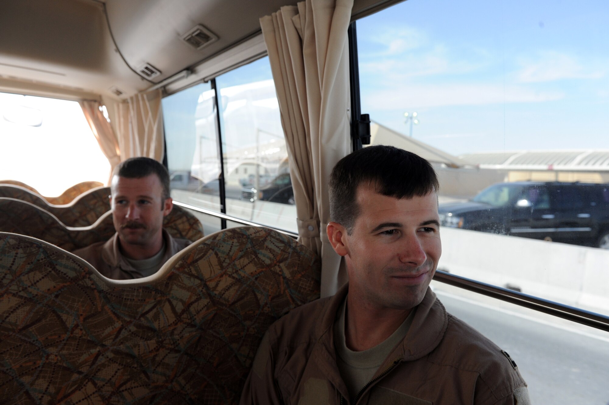 Capt. Conor Daugherty and Capt. Jason Wright ride a crew bus to their awaiting aircraft prior to the last mission of their six-month deployment Jan. 23, 2010, at an air base in Southwest Asia. Captain Daugherty is a B-1B Lancer defensive systems operator. Captain Wright is a B-1B pilot. Both are assigned to the 37th Expeditionary Bomb Squadron. (U.S. Air Force photo/Staff Sgt. Manuel J. Martinez)
