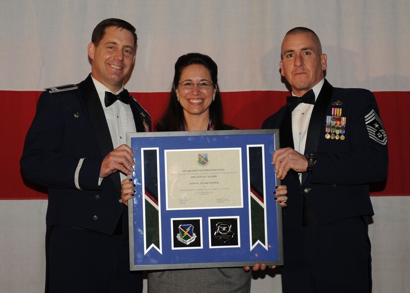 MOODY AIR FORCE BASE, Ga. -- Victoria Johnson, 93rd Air Ground Operations Wing Civilian of the Year Technical, Clerical & Other Award winner, poses for a photo with (left) Col. John Horner, 93rd AGOW commander, and (right) Command Chief Master Sgt. Thomas Vallely, 93rd AGOW command chief master sergeant, during the 2009 Annual Awards Ceremony held at the James H. Rainwater Conference Center in Valdosta, Ga., Jan. 30. (U.S. Air Force photo by Senior Airman Gina Chiaverotti-Paige)