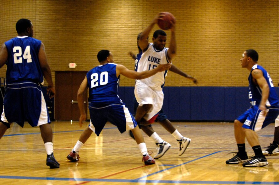 Luke team member Senior Airman Albert Banks, 756th Aircraft Maintenance Squadron aircraft airmerment systems journeyman, attempts to break trhought a wall of defenders during the Varsity Basketball Game against Davis-Monthan at Luke Air Force Base, Ariz, Jan 30, 2009. (U.S. Air Force Photo by Staff Sgt. Jason Colbert)