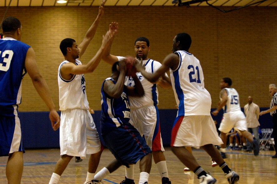Members of the Luke team stop a member of the DM team from shooting during the Varsity Basketball Game against Davis-Monthan at Luke Air Force Base, Ariz, Jan 30, 2009. (U.S. Air Force Photo by Staff Sgt. Jason Colbert)