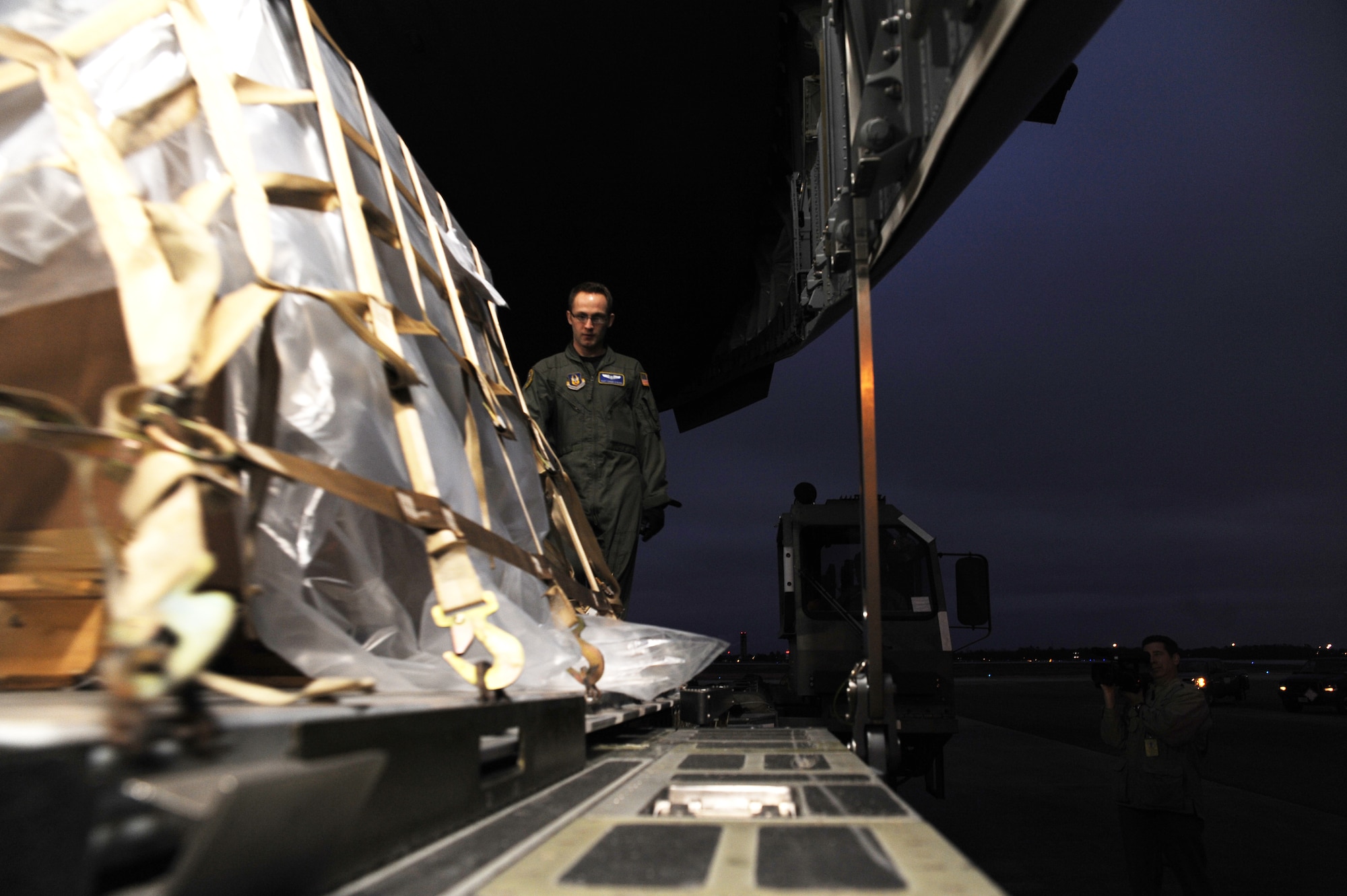 Staff Sgt. Chuck O'Guinn pushes a high-priority pallet of cargo onto a C-17 Globemaster III from Travis Air Force Base, Calif., while parked Jan. 22, 2010, at Charleston Air Force Base, S.C. The pallet included a large amount of money in support of the U.S. Embassy in Port-au-Prince, Haiti. Sergeant O'Guinn is a loadmaster from the 728th Airlift Squadron at McChord AFB, Wash. (U.S. Air Force photo/Senior Airman Katie Gieratz)