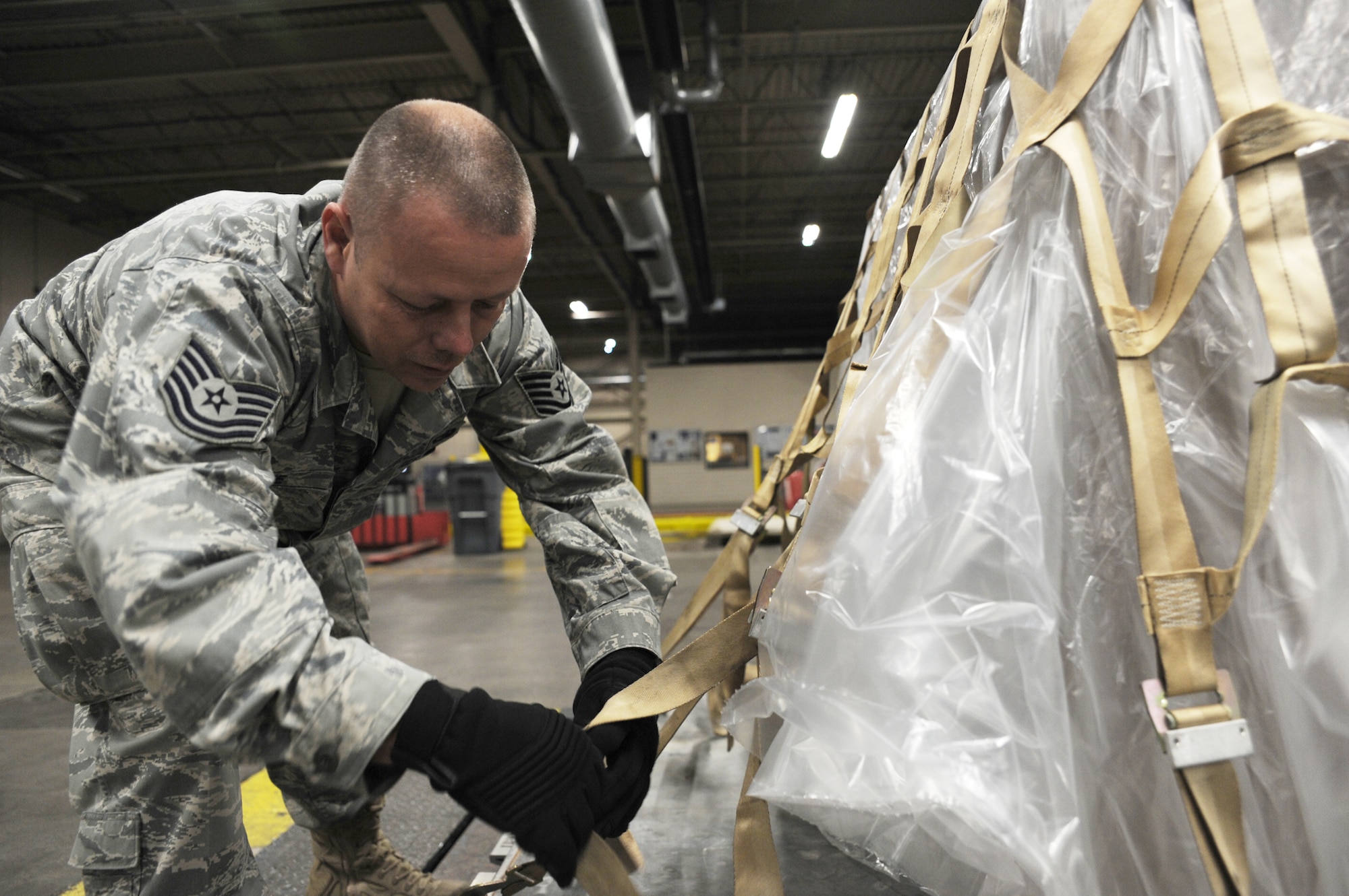 Tech. Sgt. Tim Crowe ties down pallet supporting more than 800 pounds in U.S. currency Jan. 22, 2010, at Charleston Air Force Base, S.C. The package contained a large amount of money to support the U.S. Embassy in Port-au-Prince, Haiti. Sergeant Crowe is a special handling supervisor with the 437th Aerial Port Squadron. (U.S. Air Force photo/Senior Airman Katie Gieratz)
