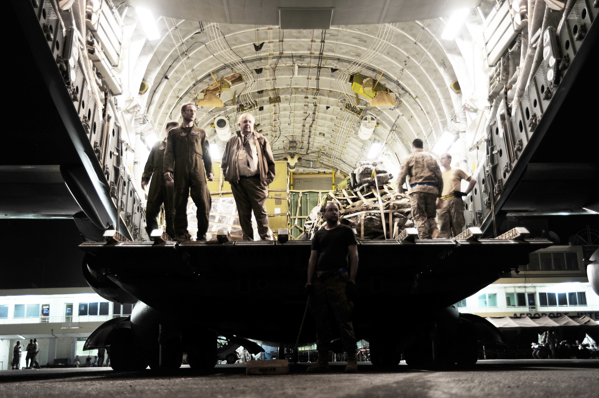 Air Force members and Richard Ivy (right) wait to unload a shipment of U.S. currency from a Travis Air Force Base, Calif., C-17 Globemaster III Jan. 22, 2010, at Port-au-Prince, Haiti. The important package was a large sum of money scheduled for delivery to the U.S. Embassy in Port-au-Prince. Mr. Ivy is a U.S. State Department disbursing officer. (U.S. Air Force photo/Senior Airman Katie Gieratz)