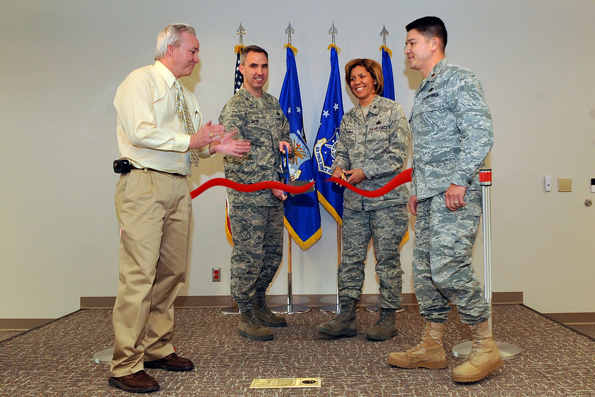 (From left) Mr. Larry Wilkerson, 21st Space Wing installation deployment officer, Col. Stephen N. Whiting, 21st SW commander, Col. Emily Buckman, 21st Mission Support Group commander, and Maj. Jerry Gonzalez, 21st Logistics Readiness Squadron commander, cut the ceremonial ribbon at Building 123 during the Jan. 22 LRS deployment facility re-opening ceremony. (Air Force photo by Rob Bussard)


