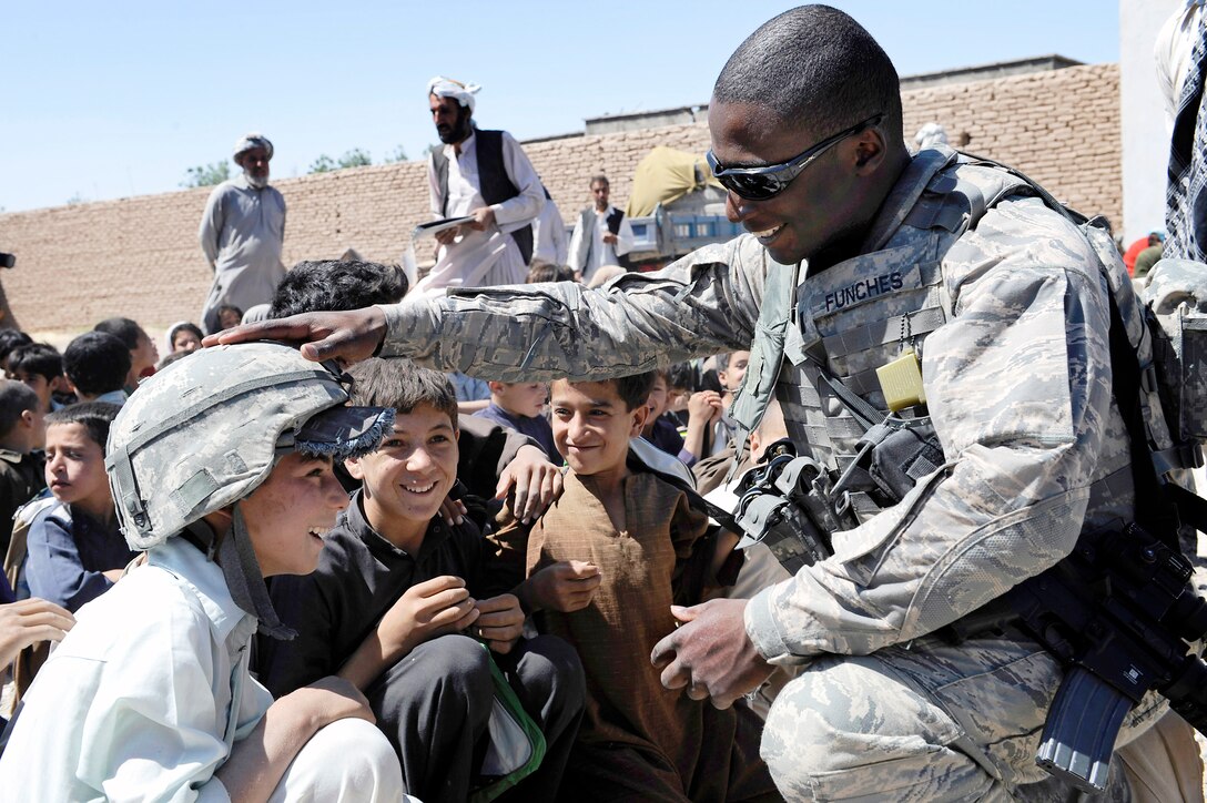 At Rhey Village near Herat, Afghanistan, 1st Lt. Etan Funches lets an Afghan boy try on his helmet, Sept. 2, 2009. Lieutenant Funches is deployed to nearby Camp Stone from Schriever Air Force Base, Colo. (U.S. Air Force photo/Senior Airman Marc I. Lane)