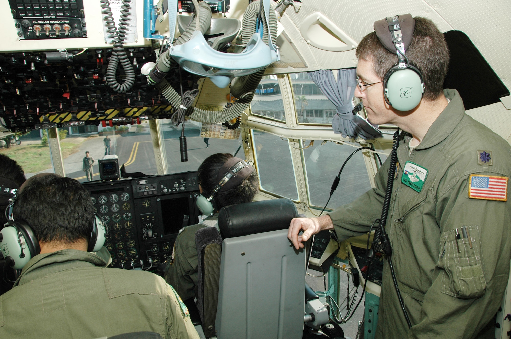 Lt. Col. Ted Treffeisen observes members of the Royal Thai air force as they run preflight checklists at Phitsanulok Royal Thai Air Force Base, Thailand. Seven members of the 302nd Airlift Wing traveled to Thailand to provide expert training to RTAF members on safe and effective modular airborne firefighting system operations. Colonel Treffeisen is the chief of training for the Air Force Reserve's 302nd AW based at Peterson AFB, Colo. (U.S. Air Force photo/Capt. Jody L. Ritchie)