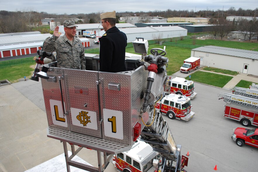 Tech. Sgt. Eric Hartman re-enlists into the 442nd Civil Engineers Squadron, where he is part of the Fire Protection Flight, Nov. 24, 2009. Sergeant Hartman took his oath of enlistment atop a 100-foot aeriel ladder platform provided by his employer, the Columbia, Mo. Fire Department. The oath was administered by Navy Lt. Timothy Anderson, commander, Navy ROTC- University of Missouri-Columbia. The ceremony was attended by Sergeant Hartman's wife, Rachel, Tech. Sgt. Joseph Moore, 442nd recruiting office, and fellow Columbia firefighter Master Sgt. Jeffrey Strawn, 442nd Civil Engineers Squadron. The 442nd Civil Engineers Squadron is part of the 442nd Fighter Wing, an Air Force Reserve unit at Whiteman Air Force Base, Mo. (U.S. Air Force photo/ James Weaver)
