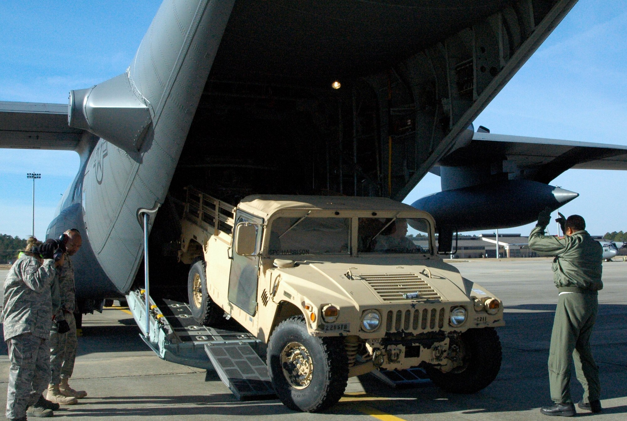 Chief Master Sgt. Byron Todd (far right) guides Army Staff Sgt. Luke Skinner as he backs a satellite communication uplink trailer into an awaiting Air Force Reserve C-130 Hercules Jan. 27, 2010, at Pope Air Force Base, N.C. Sergeant Skinner and more than 10 members of his unit later arrived at Port-au-Prince, Haiti, where they deployed in support of earthquake relief operations. Chief Todd is a loadmaster assigned to the Minnesota Air National Guard's 133rd Airlift Wing in Minneapolis-St. Paul. Sergeant Skinner is assigned to the 82nd Airborne Division. (U.S. Air Force photo/Staff Sgt. Stephen J. Collier)