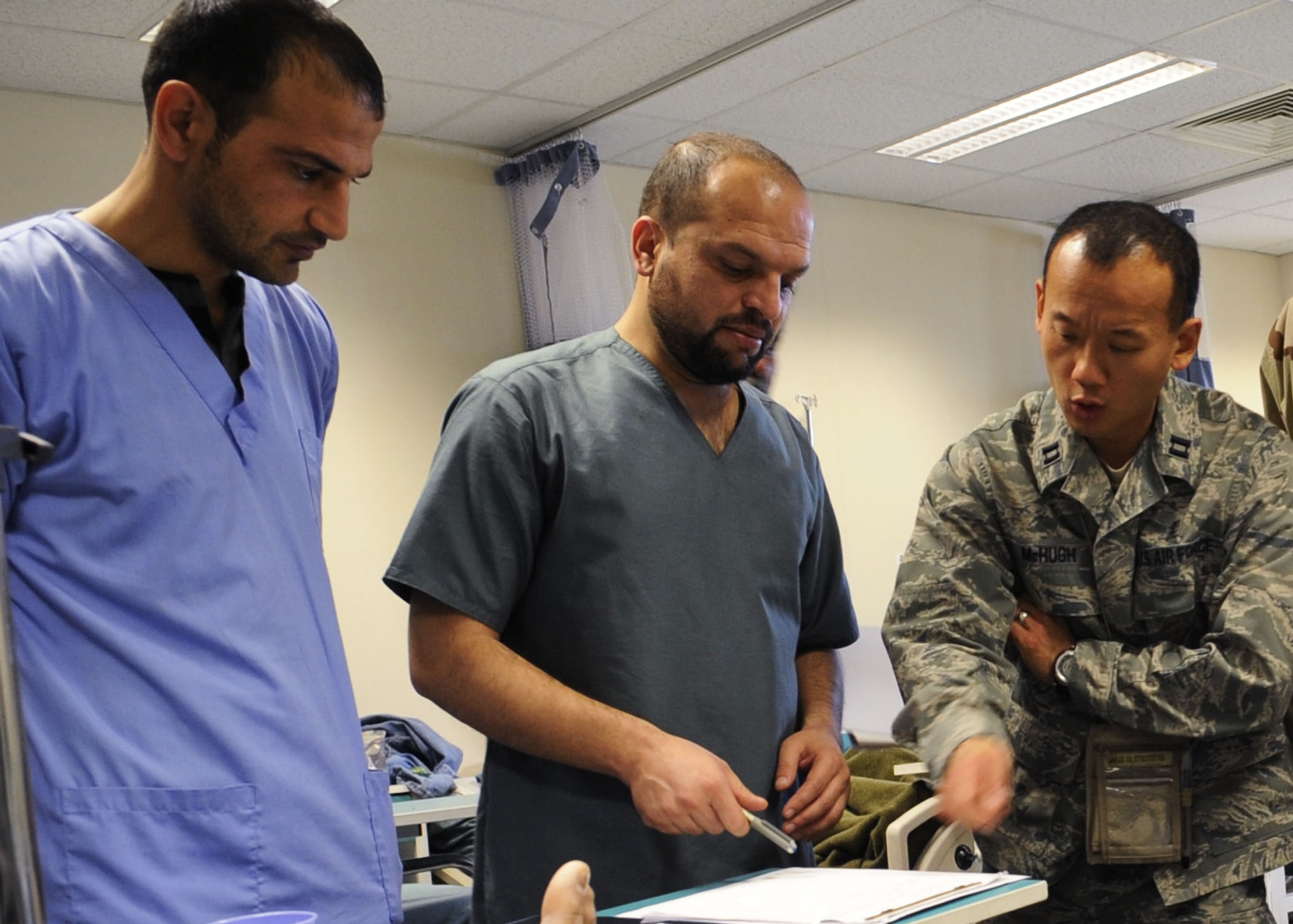 Dr. (Capt.) Ryan McHugh, right, an anesthesiologist mentor, discusses an appendicitis patient’s condition with Afghan doctors in a ward within the Kandahar Regional Medical Hospital Jan. 30, 2010. Dr. McHugh is a mentor with the Medical Embedded Training Team on Camp Hero, Afghanistan. (U.S. Air Force photo/Senior Airman Nancy Hooks/Released)