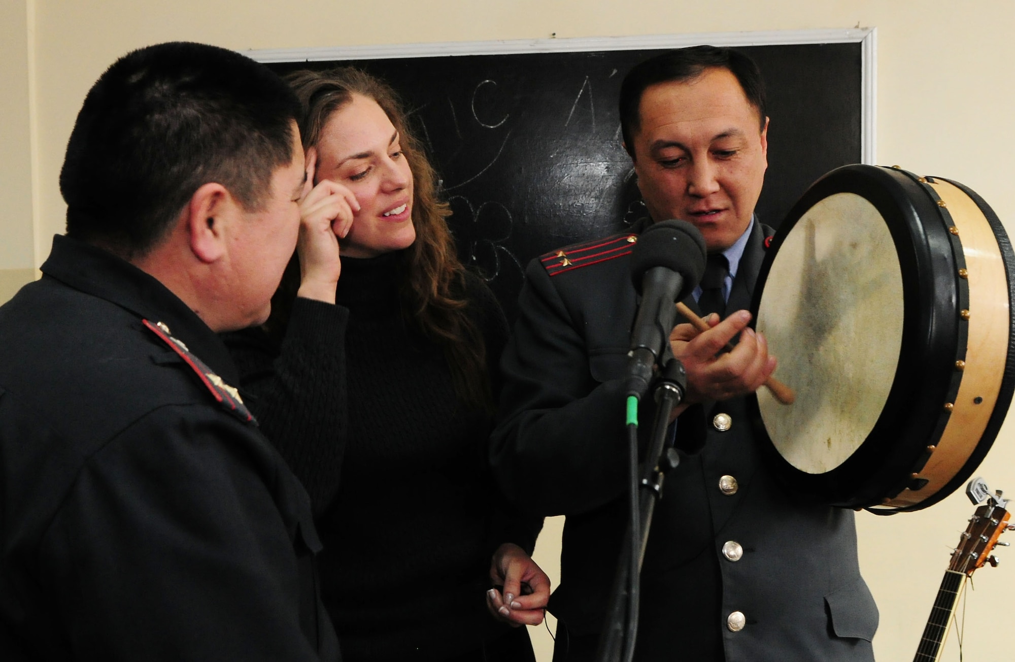 U.S. Air Force Tech. Sgt Julia Brundage teaches Kyrgyz Lt. Col. Kubamych Tezekov how to play the bodhram after performing for instructors and students of the Police Academy in Bishkek, Kyrgyzstan, Jan. 28, 2010. Sergeant Brundage is a vocalist and multi-instrument player for the U.S. Air Forces Central Public Affairs band "Celtic Aire." (U.S. Air Force photo/Senior Airman Nichelle Anderson/released)
