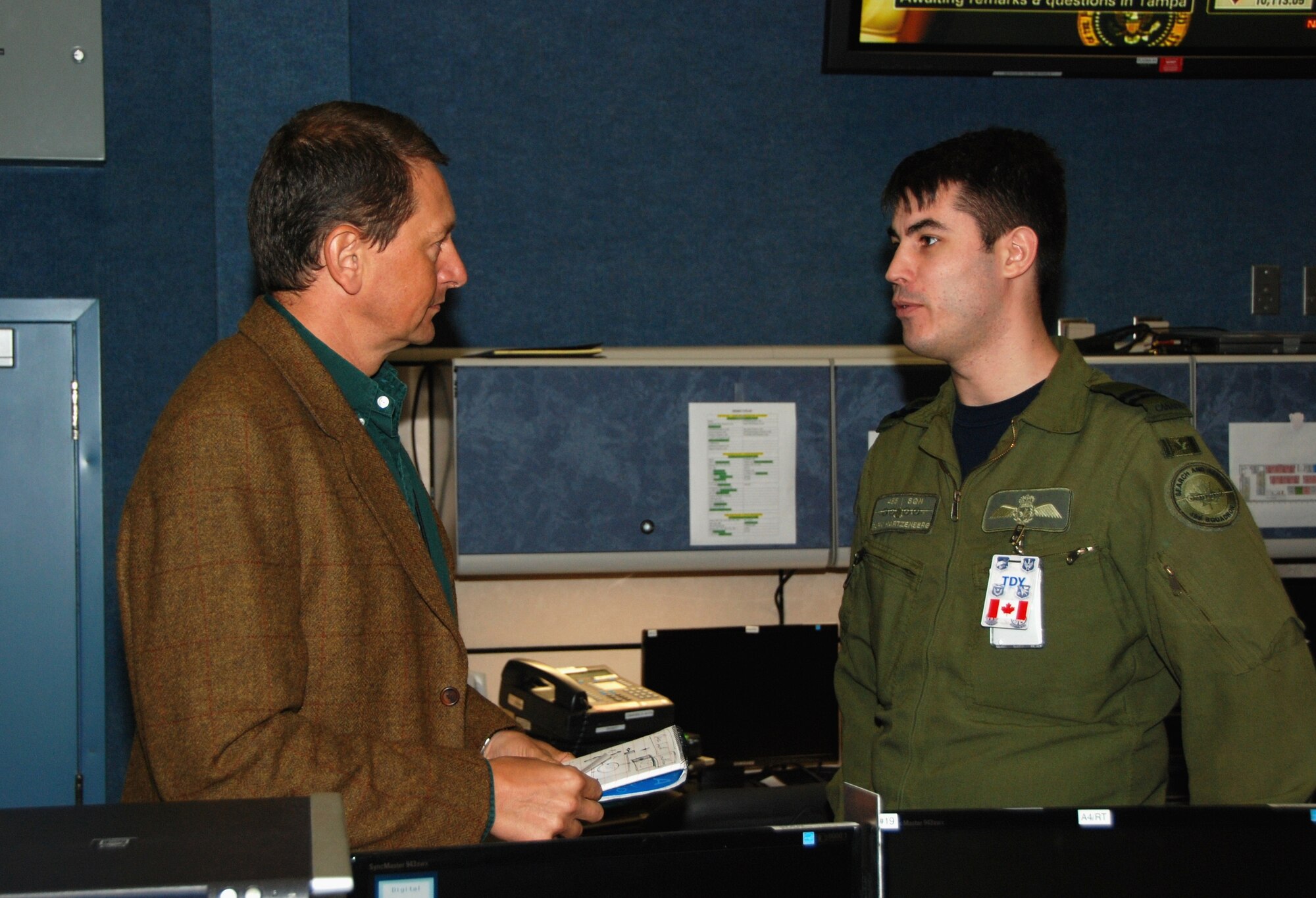 Phillipe Martou, deputy chief of aviation services for the U.N. World Food Programme, discusses slot time allocation with Canadian Capt. Gary P.Hartzenberg, 435th Squadron.  Both men are providing support to the Haiti Flight Operations Coordination Center, 601st Air & Space Operations Center, Tyndall AFB, Fla.
