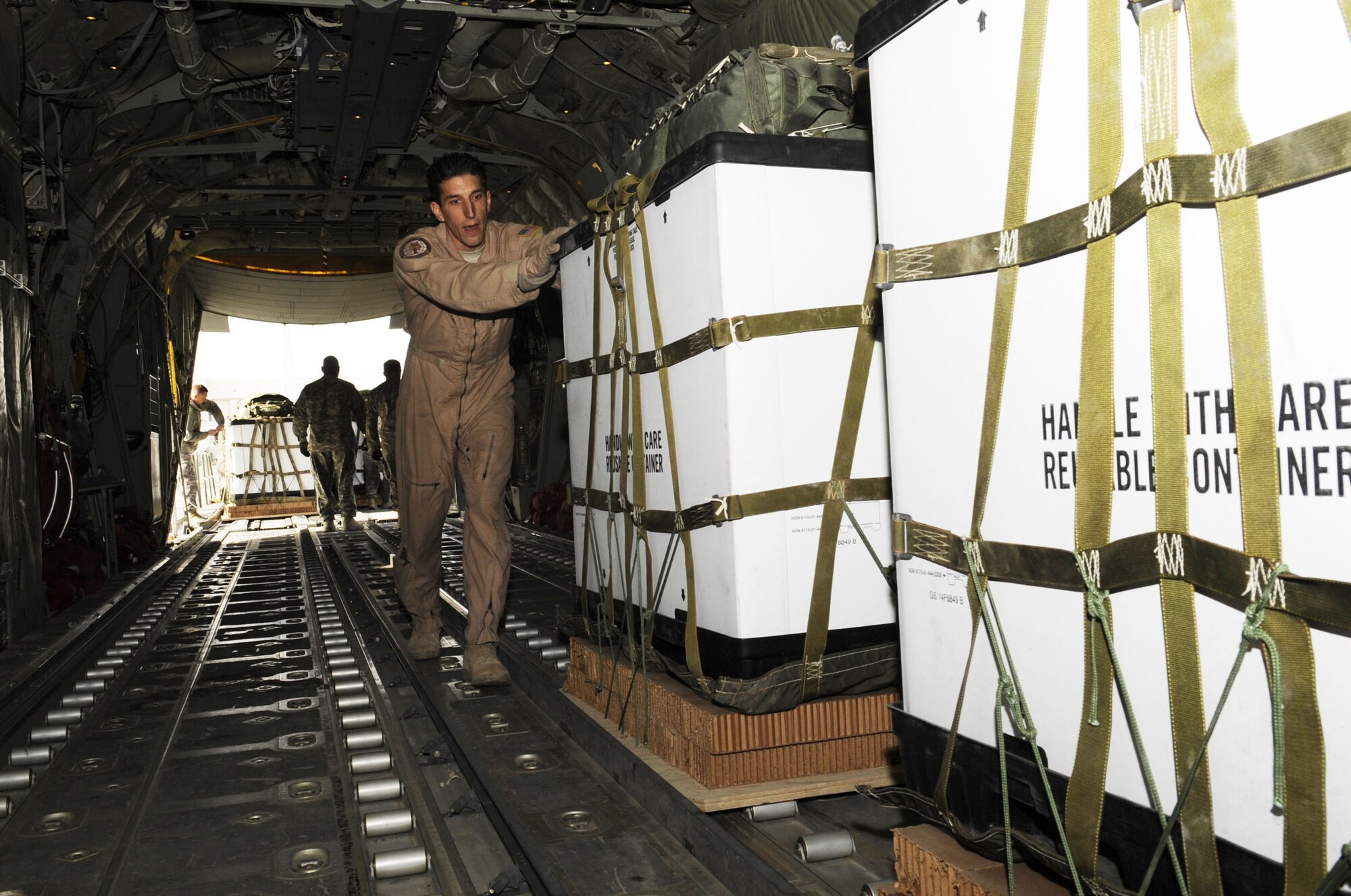 Tech. Sgt. Jay Krahl, 772nd Expeditionary Airlift Squadron loadmaster, helps upload containerized delivery systems onto a C-130J Super Hercules here, Jan. 29, 2010. The 82nd Airborne Corps’ new rigging facility on Kandahar Airfield will allow Soldiers to build more CDS bundles filled with supplies needed to be airdropped to forward operating bases within Afghanistan. The 772nd Expeditionary Airlift Squadron's airdrop support will then be increased by 250 percent. (U.S. Air Force photo/Senior Airman Nancy Hooks/Released) 