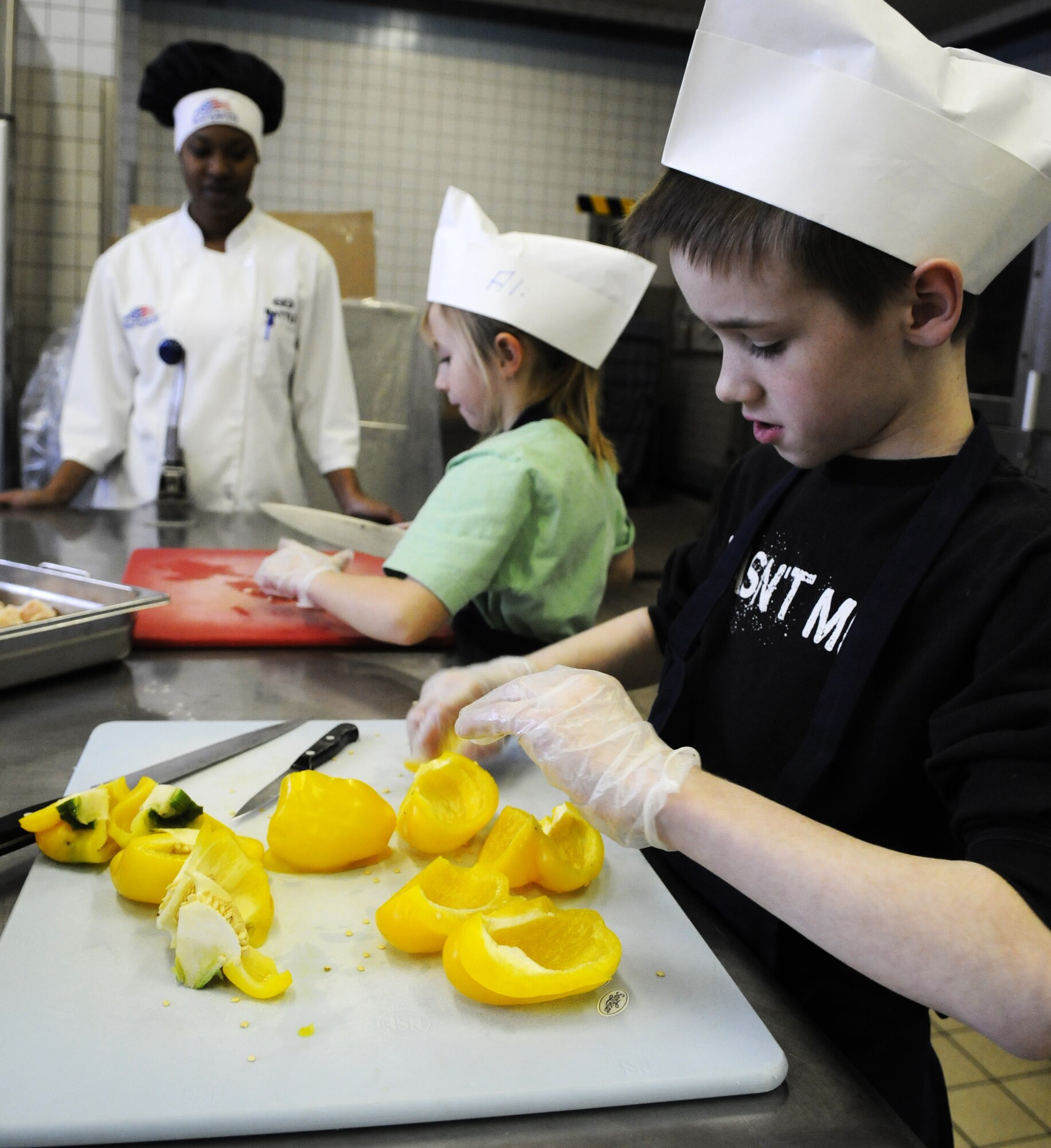 SPANGDAHLEM AIR BASE, Germany – William Moreau, son of Tech. Sgt. Jay Moreau, 52nd Civil Engineer Squadron, chops peppers for Team Three during the Kid’s Iron Chef Competition at the Mosel Dining Facility Jan. 27. Students from the Spangdahlem Middle School were split into three teams, and each team created a different dish to be judged. Team Three took first place with their sweet chicken curry dish.  (U.S. Air Force photo/Airman 1st Class Staci Miller)