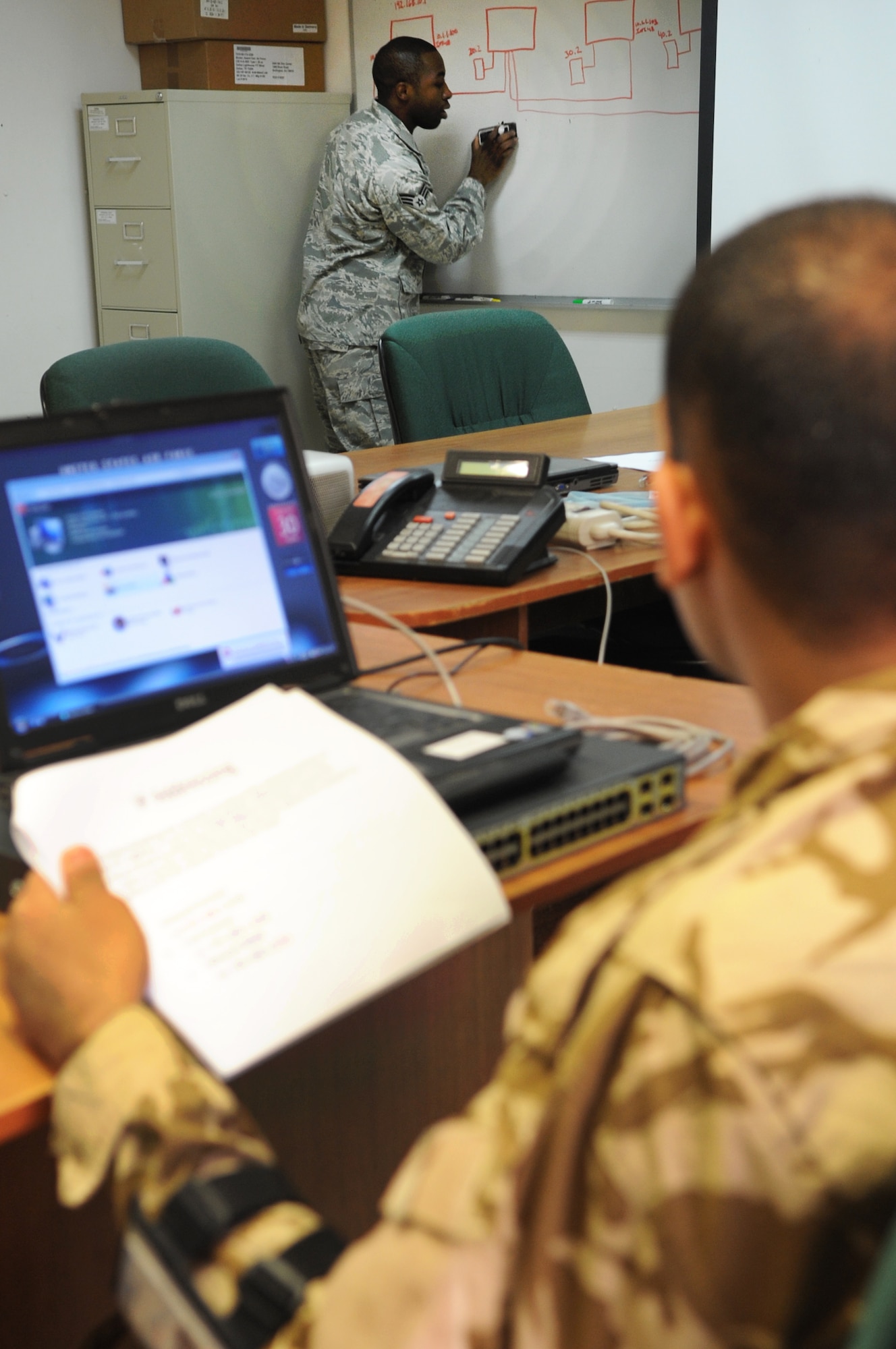 KIRKUK REGIONAL AIR BASE, Iraq –Senior Airman Andre Taylor, 506th Expeditionary Communications Squadron computer switching and cryptographic technician, teaches Iraqis basic configurations of communication methods Jan. 30, 2010. The first session covered basic communication information, starting small and progressing gradually after each session - the end goal being self support. This training is another step in the nation building component of the Air Force's mission to foster Iraqi self sufficiency. (U.S. Air Force photo/Staff Sgt. Tabitha Kuykendall)	     