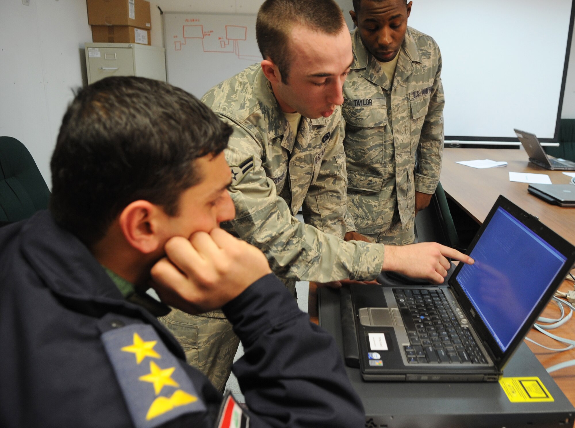 KIRKUK REGIONAL AIR BASE, Iraq – Iraqi air force members learn communication techniques from Senior Airman Andre Taylor and Airman 1st Class Chris Redman, 506th Expeditionary Communications Squadron, Jan. 30, 2010. The 506th ECS is conducting six training sessions, which will touch on various areas of communication techniques. This training is another step in the nation building component of the Air Force's mission to foster Iraqi self sufficiency. (U.S. Air Force photo/Staff Sgt. Tabitha Kuykendall)	       