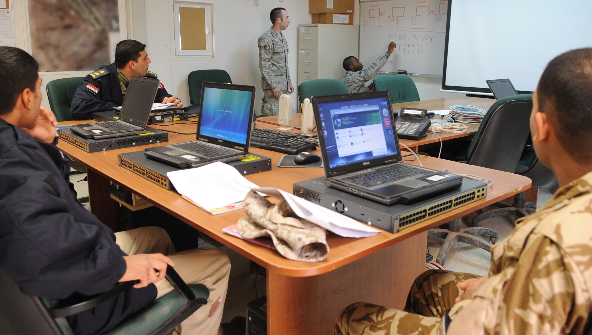 KIRKUK REGIONAL AIR BASE, Iraq – Four Iraqi air force members learn communication techniques from Senior Airman Andre Taylor and Airman 1st Class Chris Redman, 506th Expeditionary Communications Squadron, Jan. 30, 2010. The 506th ECS is conducting six training sessions, which will touch on various areas of communication techniques. This training is another step in the nation building component of the Air Force's mission to foster Iraqi self sufficiency. (U.S. Air Force photo/Staff Sgt. Tabitha Kuykendall)	       