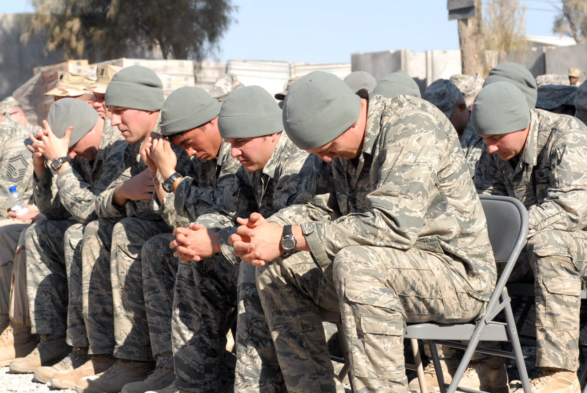 Explosive ordnance disposal Bravo Flight team members pause in a moment of silence during a memorial ceremony Jan. 24, 2010 for fellow EOD teammate Tech. Sgt. Adam Ginett who died Jan. 19 near Kandahar Air Field, Afghanistan, of wounds suffered from an improvised explosive device.  Sergeant Ginett was deployed from Aviano Air Base, Italy to the 755th Air Expeditionary Squadron.  (U.S. Army photo/Private First Class David Hauk)