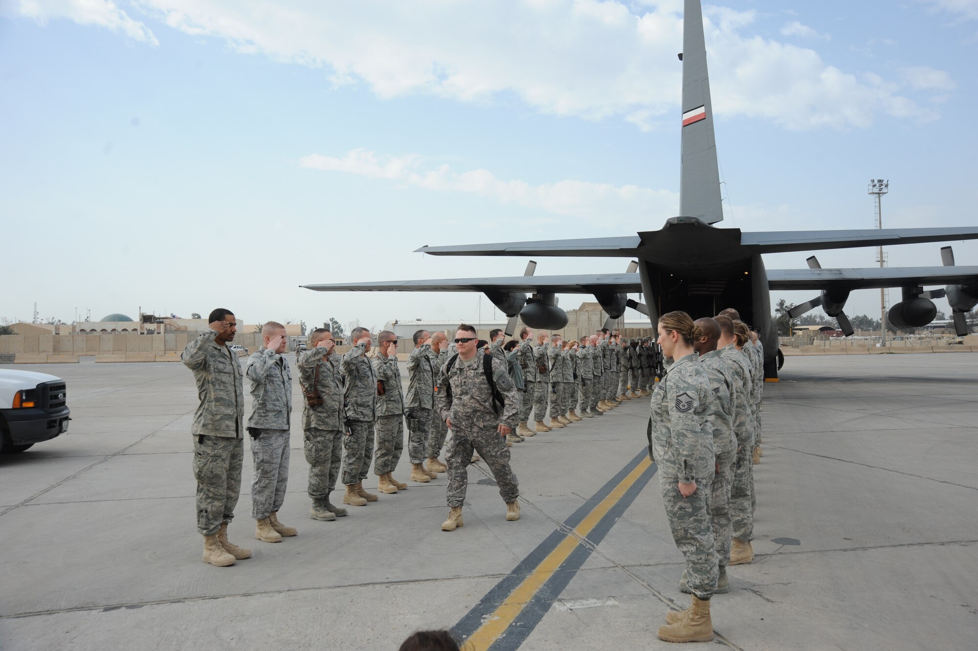 Sgt. 1st Class Joshua Olsen exits the cordon comprised of the 447th Air Expeditionary Group Airmen and Honor Guard as they start their tour around Victory Base Complex Jan.31, 2010. Operation Proper Exit is a program where service members who have been injured in Iraq revisit to help bring emotional closure. 