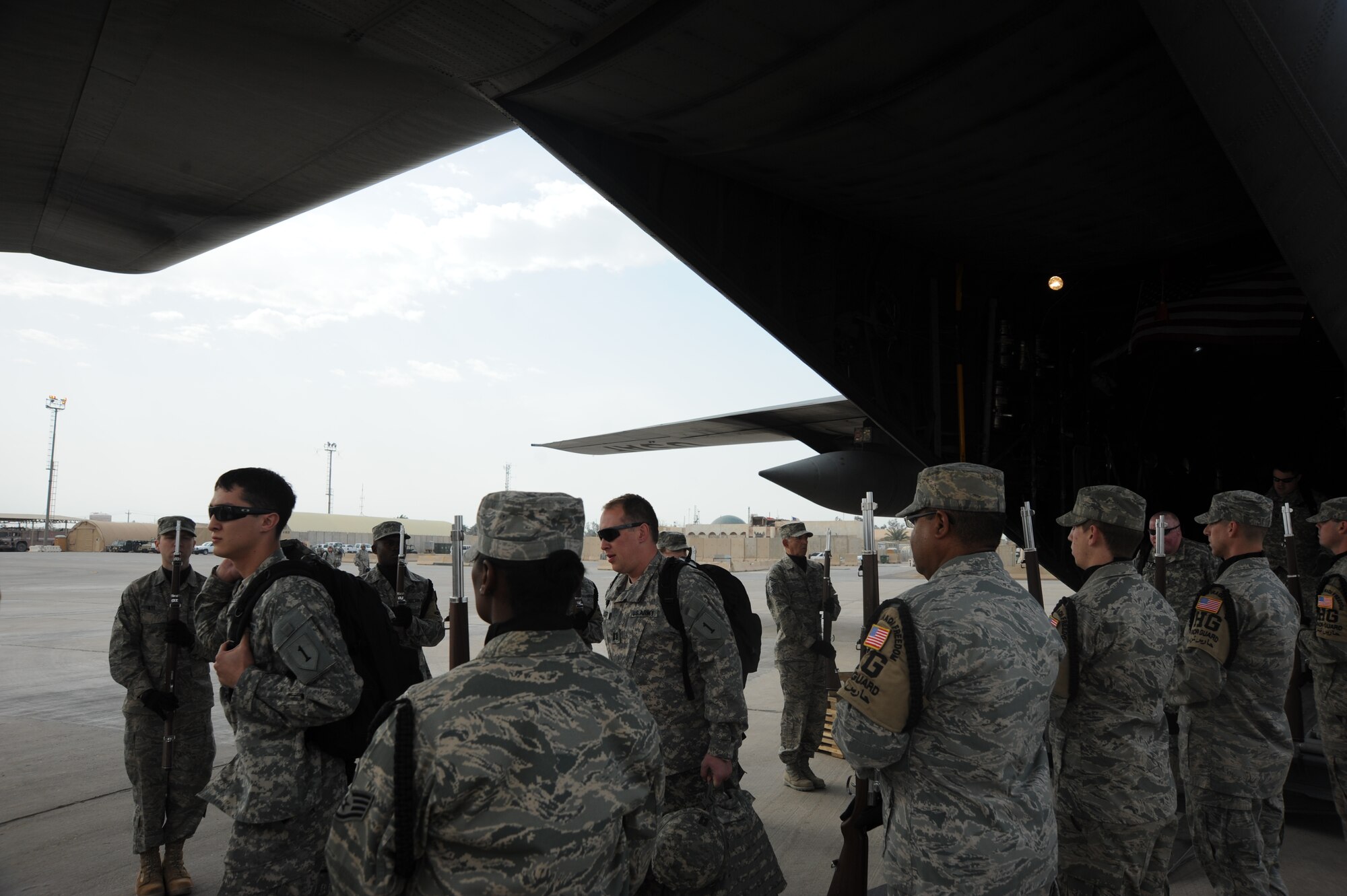 Members of Operation Proper Exit walk through a cordon comprised of the 447th Air Expeditionary Group Airmen and Honor Guard as they start their tour around Victory Base Complex. Operation Proper Exit is a program where service members who have been injured in Iraq revisit to help bring emotional closure. 