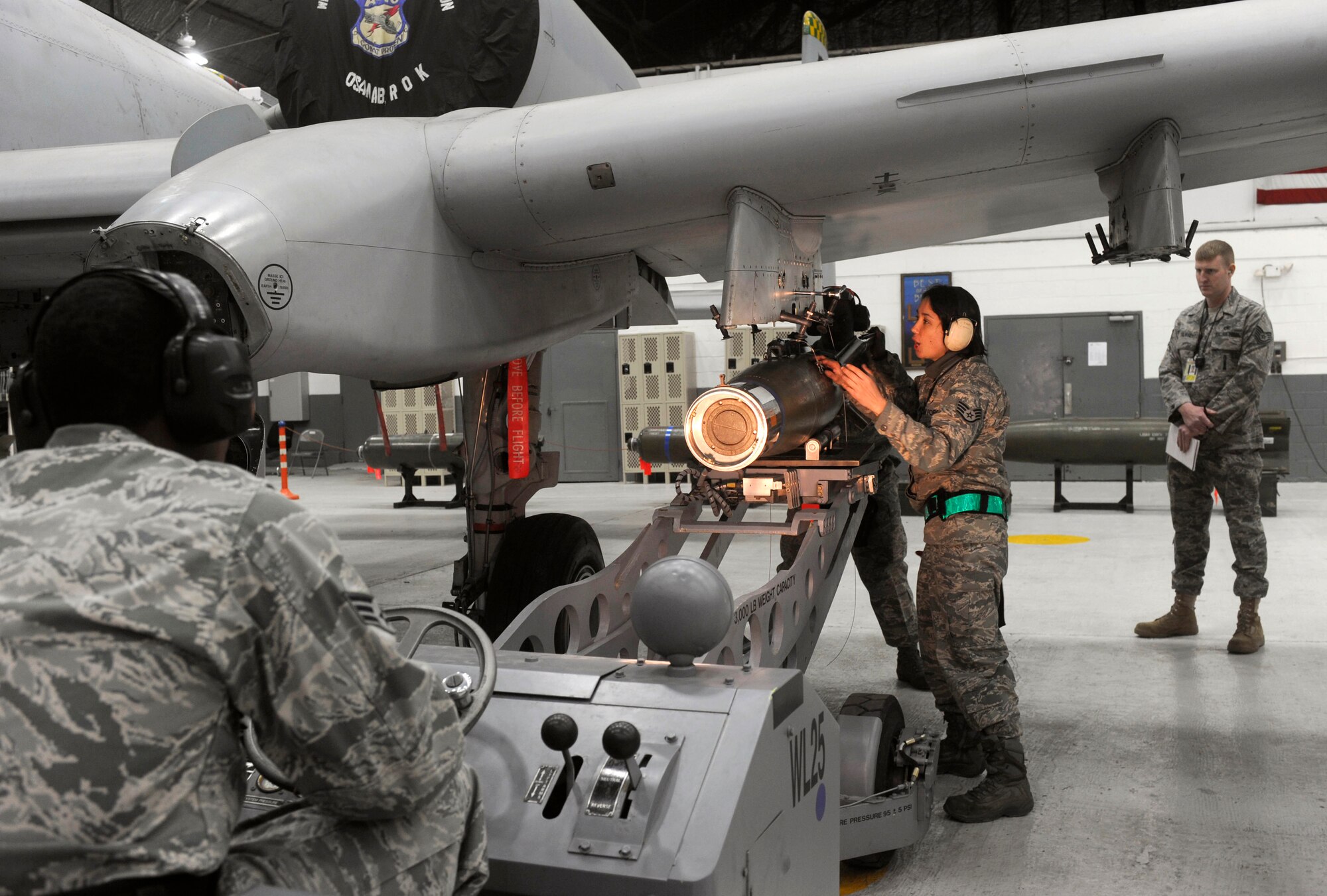 Staff Sergeant Virginia Evans loads an air-to-ground missile onto an A-10 aircraft in the fourth quarter weapons load crew competition at Osan Air Base, Republic of Korea, Jan. 29.  Sergeant Evans from is a weapons load team chief from the 51st Air Craft Maintenance Squadron. ( U.S. Air Force photo/ Senior Airman Stephenie Wade)