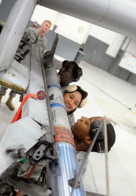 Staff Sergeant Jerry Coleman (left), Staff Sergeant Virginia Evans and Senior Airman Brandon Wallace load an air-to-ground missile onto an A-10 aircraft in the fourth quarter weapons load crew competition, at Osan Air Base, Republic of Korea, Jan. 29. They are all weapons load team members from the 51st Aircraft Maintenance Squadron.( U.S. Air Force photo/ Senior Airman Stephenie Wade)