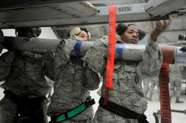 Staff Sergeant Jerry Coleman (left), Staff Sergeant Virginia Evans and Senior Airman Brandon Wallace load an air-to-ground missile onto an A-10 aircraft in the fourth quarter weapons load crew competition, at Osan Air Base, Republic of Korea, Jan. 29. They are all weapons load team members from the 51st Aircraft Maintenance Squadron.( U.S. Air Force photo/ Senior Airman Stephenie Wade)
