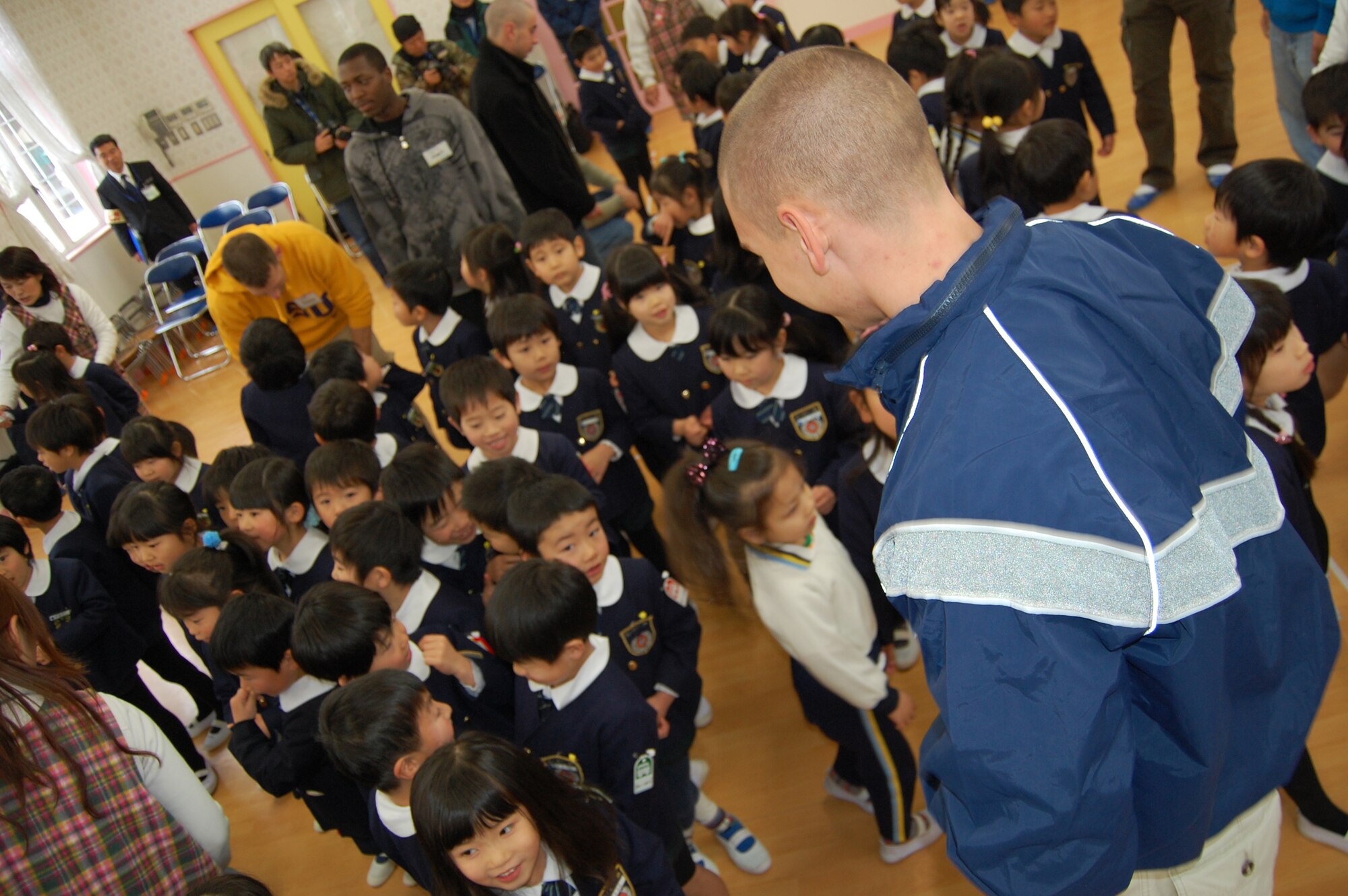 Airman 1st Class Edward Rand, 18th Security Forces Squadron, towers over students from Runbini Kindergarten near Hyakuri Air Base Feb. 1. A dozen Kadena Airmen visited the school while operating from the Japanese air base. (U.S. Air Force  photo / 1st Lt. Bryan Bouchard)