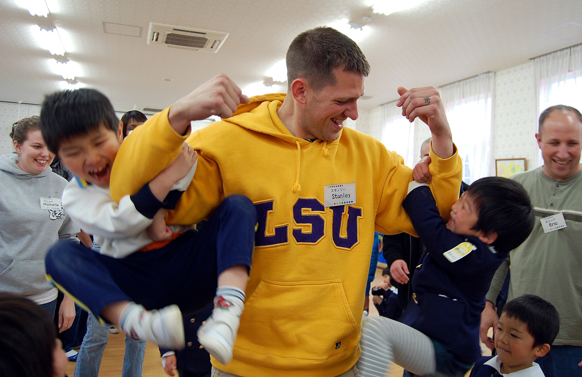 Staff Sgt. Stanley Weaver, 67th Aircraft Maintenance Unit, hoists up schoolkids from Runbini Kindergarten near Hyakuri Air Base Feb. 1. A dozen Kadena Airmen visited the school during their aviation training relocation at the Japanese base, about 70 miles north of Tokyo. (U.S. Air Force photo / 1st Lt. Bryan Bouchard)