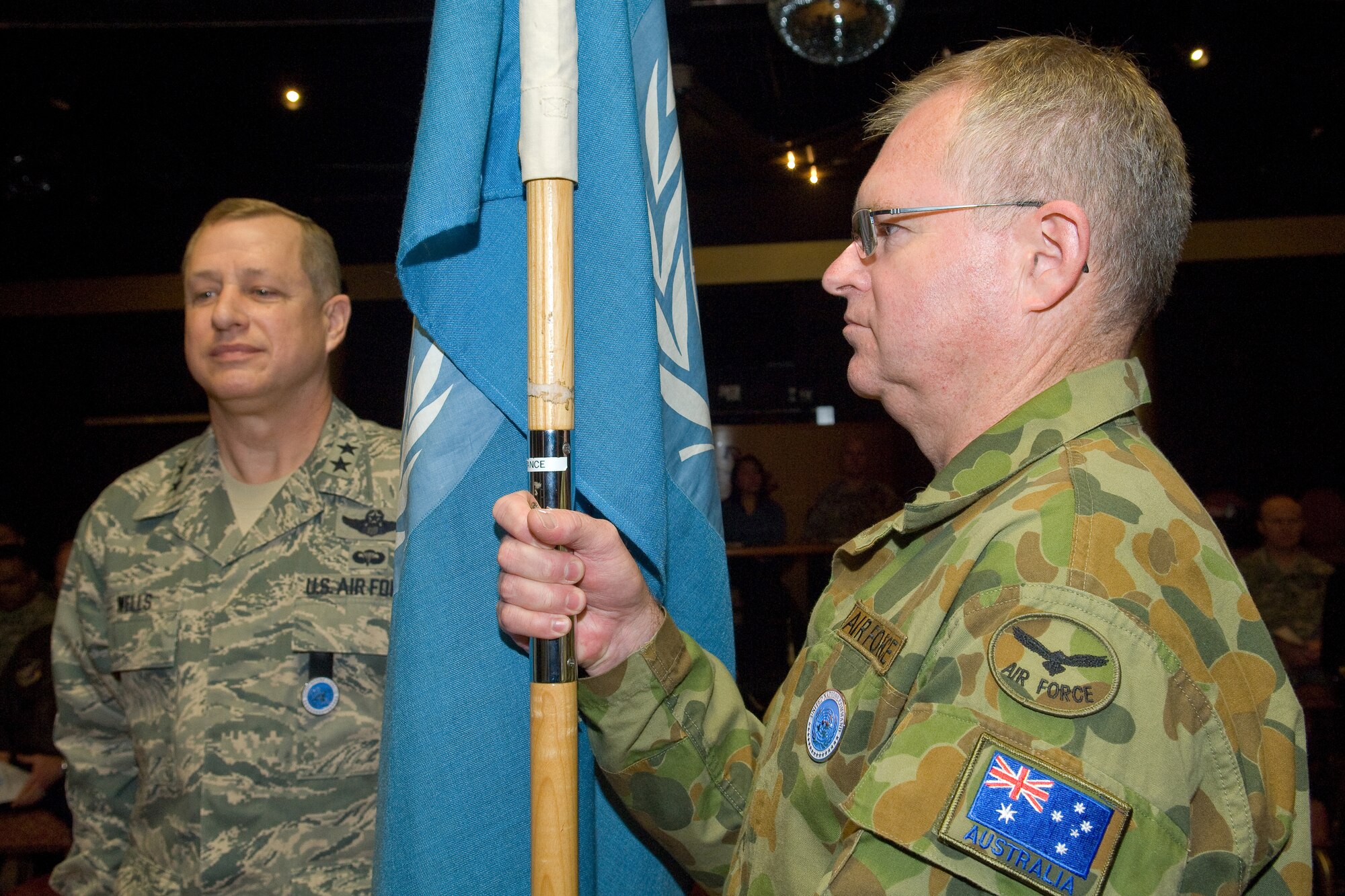 YOKOTA AIR BASE, Japan -- Group Captain Anthony McCormack, incoming United Nations Command (Rear) commander holds the guidon during the change of command ceremony Feb. 01. Group Captain McCormack is from the Royal Australian Air Force and this is first time in the history of UNC (Rear) that a non-U.S. UN officer assumes command. The UNC (Rear) is composed of eight nations accredited to the United Nations Command: Australia, Canada, France, New Zealand, The Philippines, Thailand, Turkey and the United Kingdom of Great Britain. The United Nations Command (Rear) has been located at Yokota Air base, Japan since 2007. (U.S. Air Force photo/Osakabe Yasuo)
