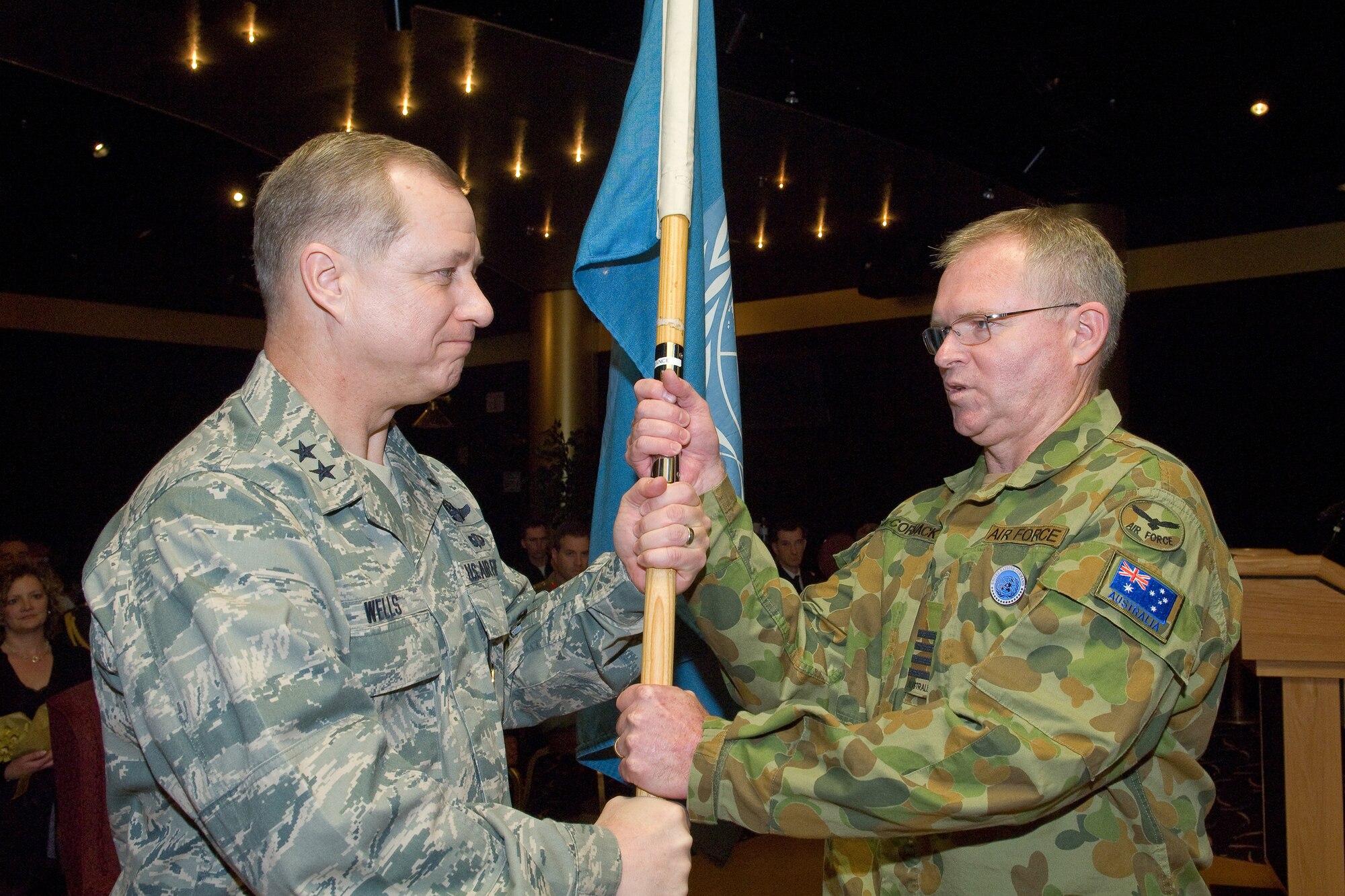 YOKOTA AIR BASE, Japan -- Group Captain Anthony McCormack, incoming United Nations Command (Rear) commander, receives the guidon from Maj. Gen. Lawrence Wells, Deputy Chief of Staff for the United Nations Command and U.S. Forces Korea, during the change of command ceremony Feb. 01. This is first time in the history of UNC (Rear) that a non-U.S. UN officer assumes command. The UNC (Rear) is composed of eight nations accredited to the United Nations Command: Australia, Canada, France, New Zealand, The Philippines, Thailand, Turkey and the United Kingdom of Great Britain. The United Nations Command (Rear) has been located at Yokota Air base, Japan since 2007. (U.S. Air Force photo/Osakabe Yasuo)