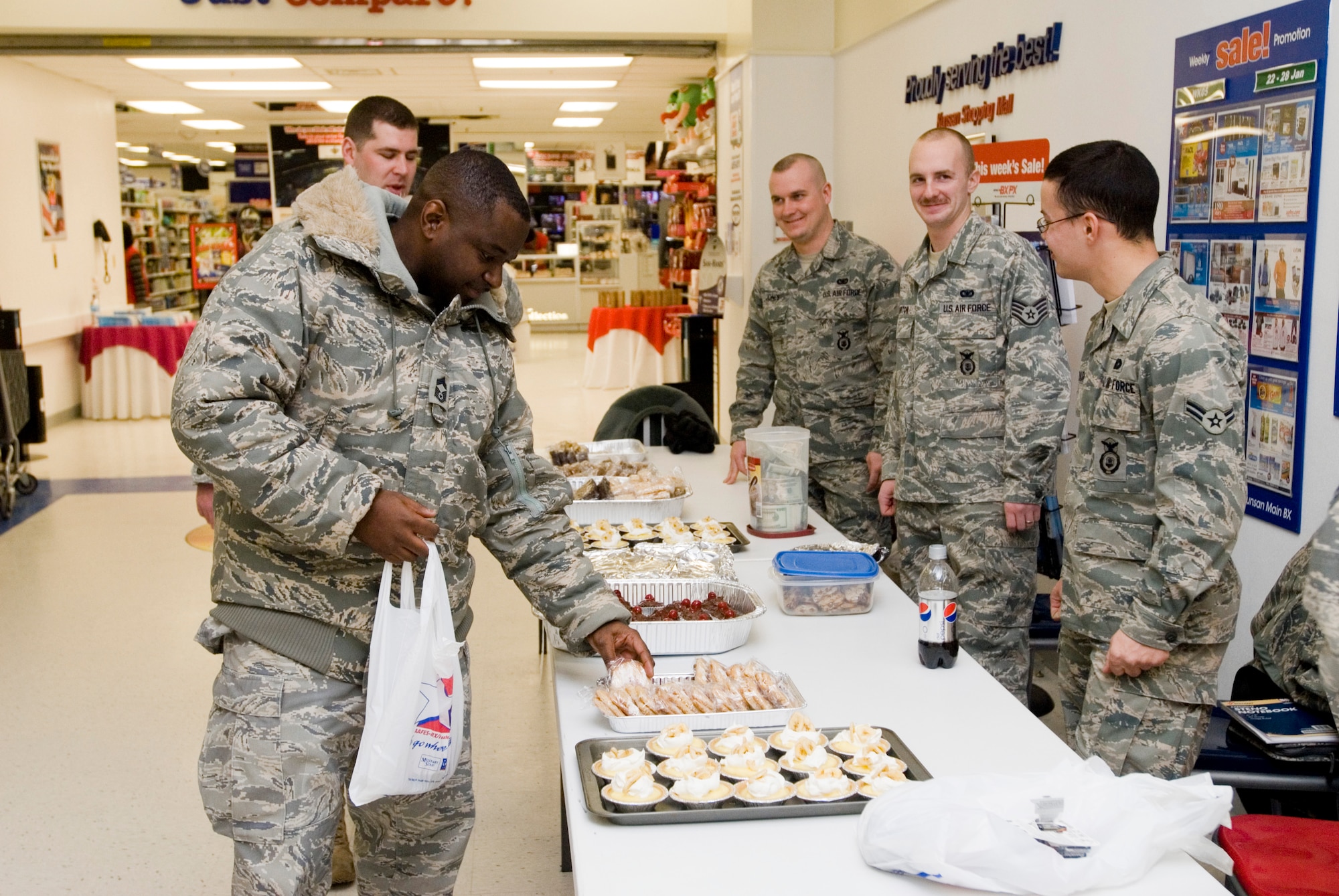 KUNSAN AIR BASE, Republic of Korea -- Chief Master Sgt. Bertell Francois, 8th Security Forces Squadron, chooses a baked good after donating money toward the Haiti disaster relief efforts Jan. 28. Fundraisers were put on by the Air Force Sergeants Association and the Security Forces Defenders Association. Wolf Pack members donated more than $1500 during the bake sale and a foreign object damage walk. The proceeds will go to The Red Cross to aid the victims of the Haiti disaster. (U.S. Air Force photo/Senior Airman Jonathan Steffen)