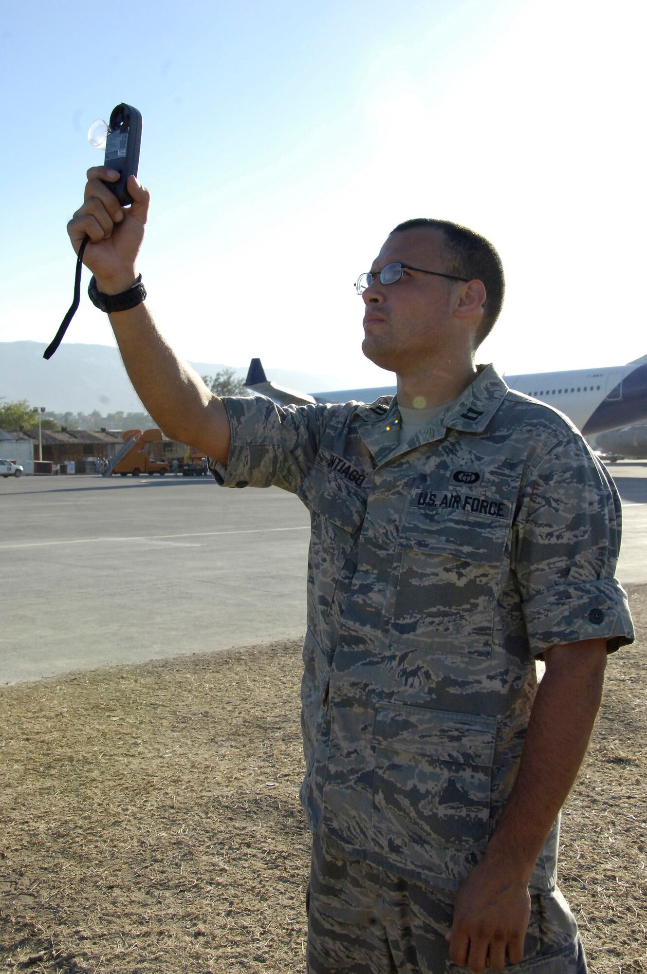 Captain Dan Santiago, Joint Special Operations Air Component weather officer, uses his Kestral pocket weather sensor at the Toussaint L'Ouverture International Airport in Port au Prince, Haiti. Capt. Santiago deployed as part of the Air Force Special Operations Contingent responsible for opening and establishing aircraft flow following the 7.1 magnitude earthquake that struck here Jan. 12. Capt. Santiago and fellow 1st Special Operations Wing weather flight weatherman Tech. Sgt. Chris Patterson employed creative solutions to overcome technological and equipment shortfalls during their deployment to Haiti. (U.S. Air Force photo by Tech. Sgt. Larry Carpenter) 