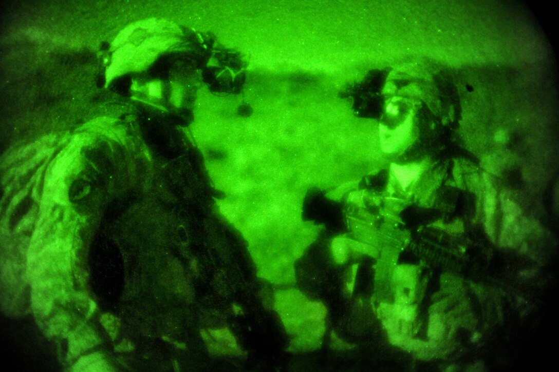 As seen through a night-vision device, U.S. Army soldiers coordinate their fire-teams before searching caves for weapons during Operation Wawraa Tufaan in Zanbar province, Afghanistan, Jan. 31, 2010.
