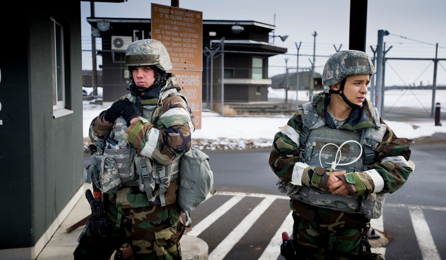 MISAWA AIR BASE, Japan -- Airman 1st Class David Cook (left) and Airman Basic Javier Padilla, 35th Security Forces Squadron entry controllers, secure one of the flightline entry-control points Feb. 2 during an operational readiness exercise. During the shift, the Airmen checked identification and performed random vehicle inspections. (U.S. Air Force photo/Senior Airman Jamal D. Sutter)