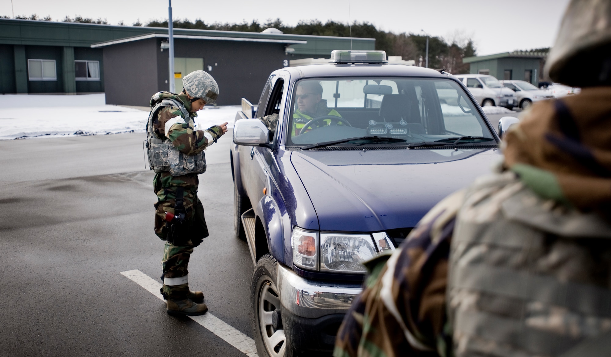 MISAWA AIR BASE, Japan -- Airman Basic Javier Padilla, 35th Security Forces Squadron entry controller, verifies identification during an operational readiness exercise Feb. 2 at a flightline entry-control point. Identification checks safeguard base personnel and assets by determining the authenticity of authorized individuals. (U.S. Air Force photo/Senior Airman Jamal D. Sutter)