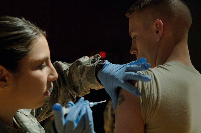 Senior Airman Victoria Marcos administers a vaccine for H1N1 influenza to Airman 1st Class Amos Hommel at the base theater here Jan. 14. The 628th Medical Group is currently administering vaccines to ensure 100 percent compliance for military personnel. The shot is highly encouraged for civilians. Airman Marcos is assigned to the 628 MDG and Airman Hommel is assigned to the 628th Communications Squadron. (U.S. Air Force photo/Airman 1st Class Lauren Main)