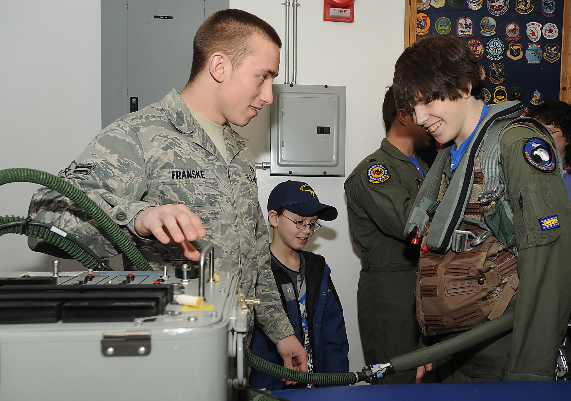 ELMENDORF AIR FORCE BASE, Alaska -- Airman 1st Class Dennis Franske, 19th Fighter Squadron shows Brendan Thompson, 19th FS's Pilot for a Day and Make-A-Wish recipient and his brother Joshua how the Gravity Suit used by F-15 pilots inflates to help keep blood from pooling the in the pilot?s lower extremities Jan 29. Brendan was diagnosed with Aplastic Anemia, a rare bone marrow cancer, and is currently receiving treatment. (U.S. Air Force photo/ Airman 1st Class Kristin High)
