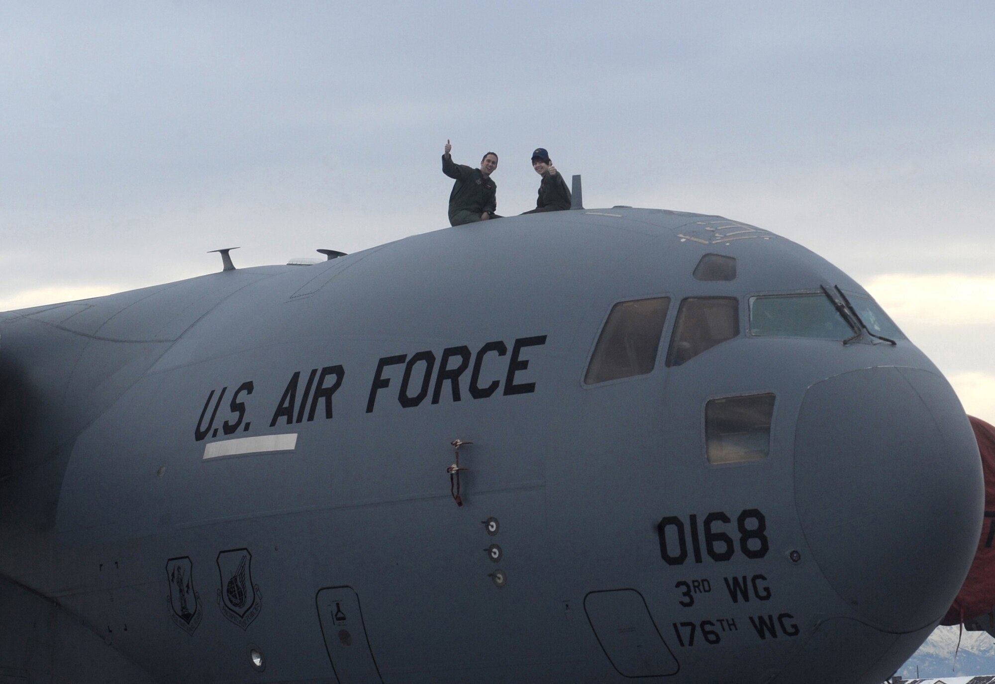 ELMENDORF AIR FORCE BASE, Alaska -- Brendan Thompson, 19 Fighter Squadron's Pilot for a Day and Make-A-Wish recipient, and Capt. John Robbins, 517 Airlift Squadron, sit on top of a C-17 Globemaster III that recently came back from supporting Haiti relief efforts Jan 29. Brendan was diagnosed with Aplastic Anemia, a rare bone marrow cancer, and is currently receiving treatment. (U.S. Air Force photo/ Airman 1st Class Kristin High)