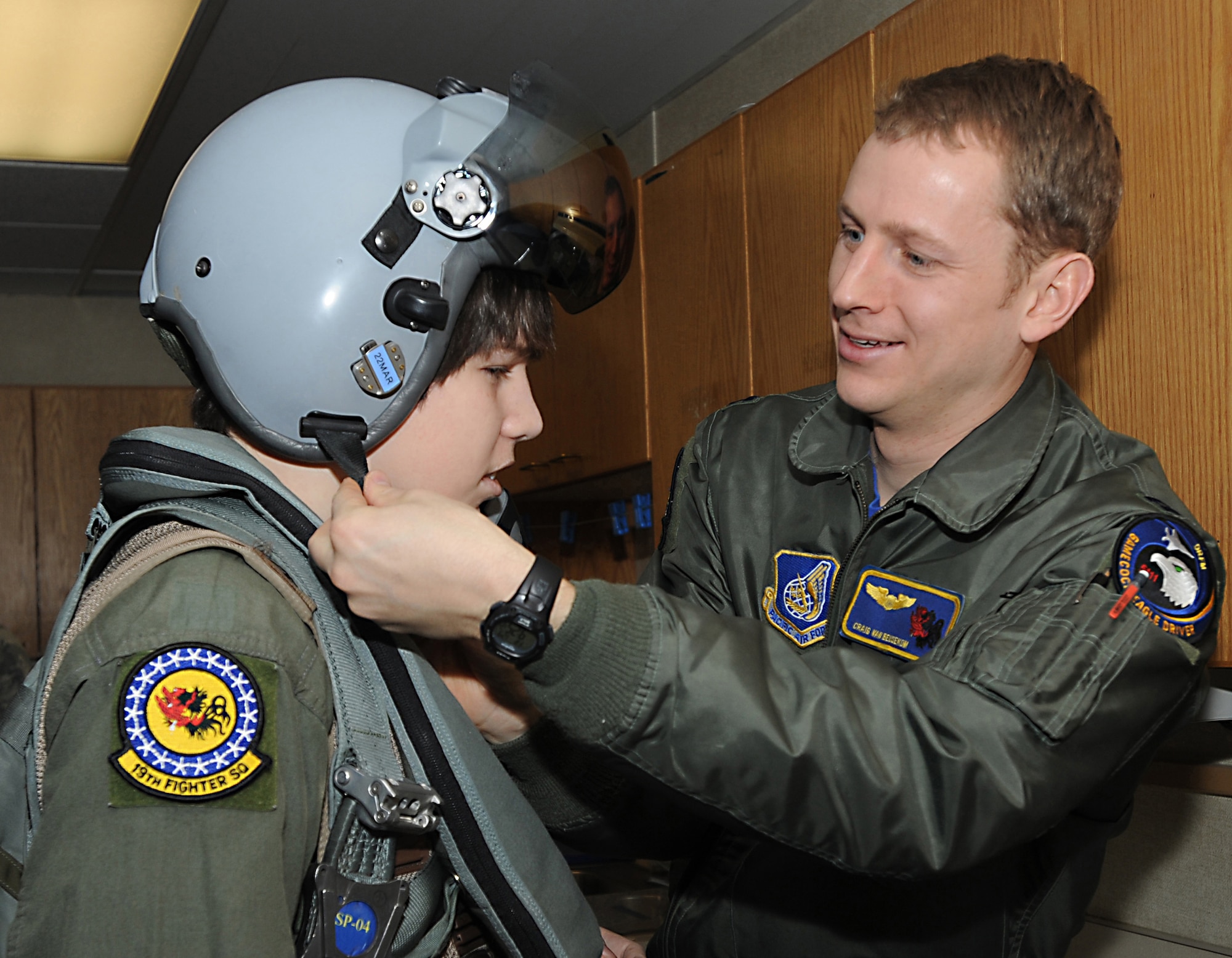 ELMENDORF AIR FORCE BASE, Alaska -- Capt. Craig Van Beusekom shows Brendan Thompson, 19th FS's Pilot for a Day and Make-A-Wish recipient the F-15 pilot Joint Helmet Mounted Cueing System used by pilots to cue weapons systems by pointing their head Jan 29. Brendan was diagnosed with Aplastic Anemia, a rare bone marrow cancer, and is currently receiving treatment. (U.S. Air Force photo/ Airman 1st Class Kristin High)