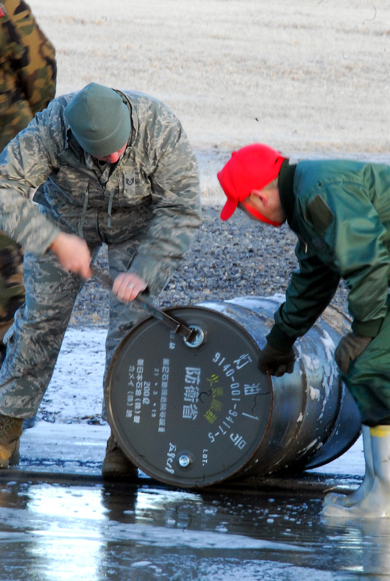 Tech. Sgt. Daniel Morris, a firefighter from the 18th Civil Engineer Squadron removes the cap from a drum of fuel for a controlled burn. He and Staff Sgt. Davie Hobbs are spending the aviation training relocation at Hyakuri Air Base working with the Japan Air Self Defense Force firefighters. (U.S. Air Force photo / 1st Lt. Bryan Bouchard)
