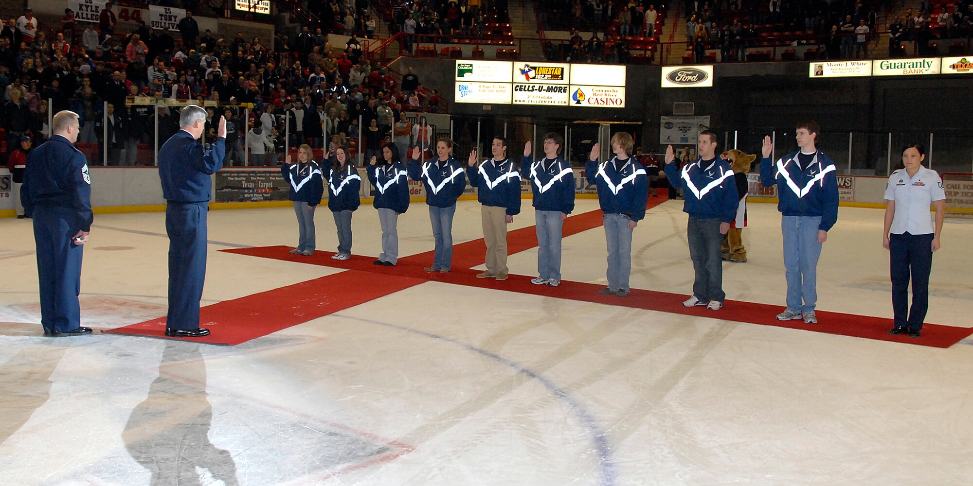 Brig. Gen. O.G. Mannon, 82nd Training Wing commander, and Chief Master Sgt. Kenneth Sallinger, 82nd TRW command chief, administer the oath of enlistment to new enlistees Jan. 30 at the Wichita Falls Wildcats Military Appreciation Game at the Kay Yeager Coliseum. (U.S. Air Force photo/Mike Litteken)